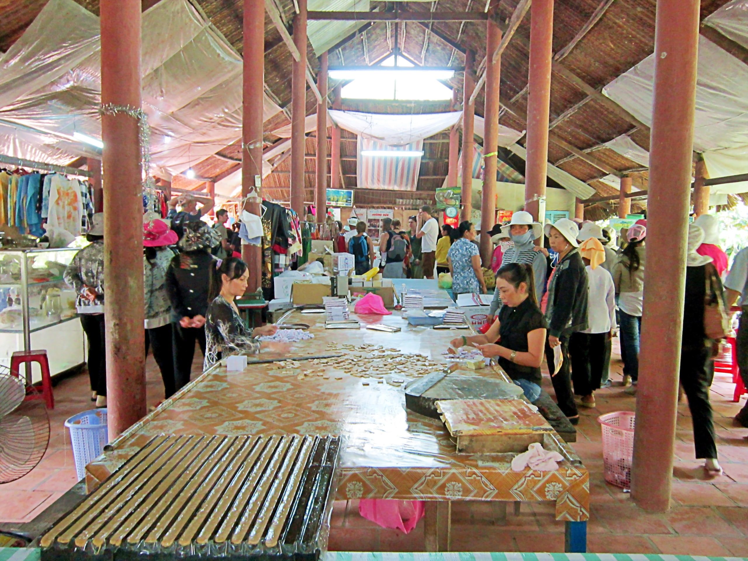 Des femmes emballent des bonbons à la noix de coco dans un atelier de Cồn Phụng