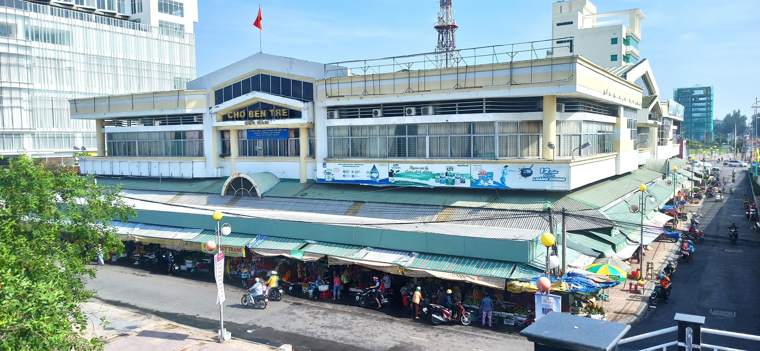 Le marché de Bến Tre, ses étals sous les auvents et le bâtiment à étages derrière