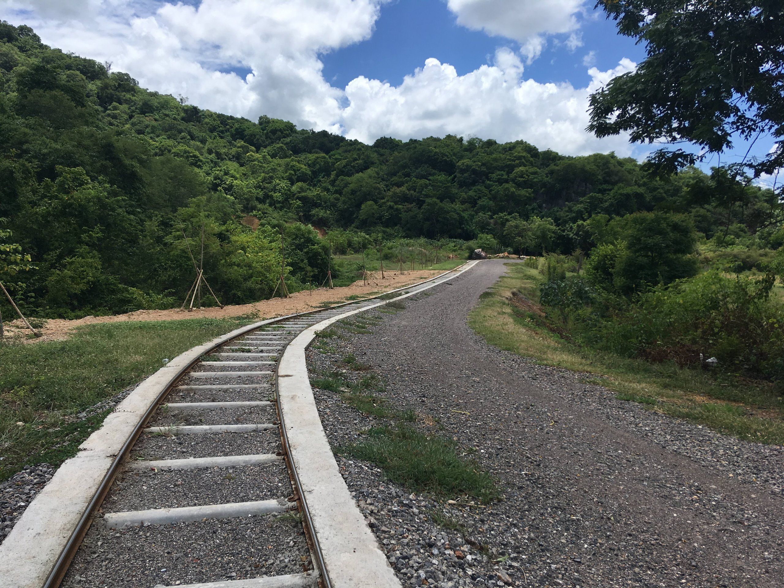 La voie du train de bambou de Banan, entre les collines boisées