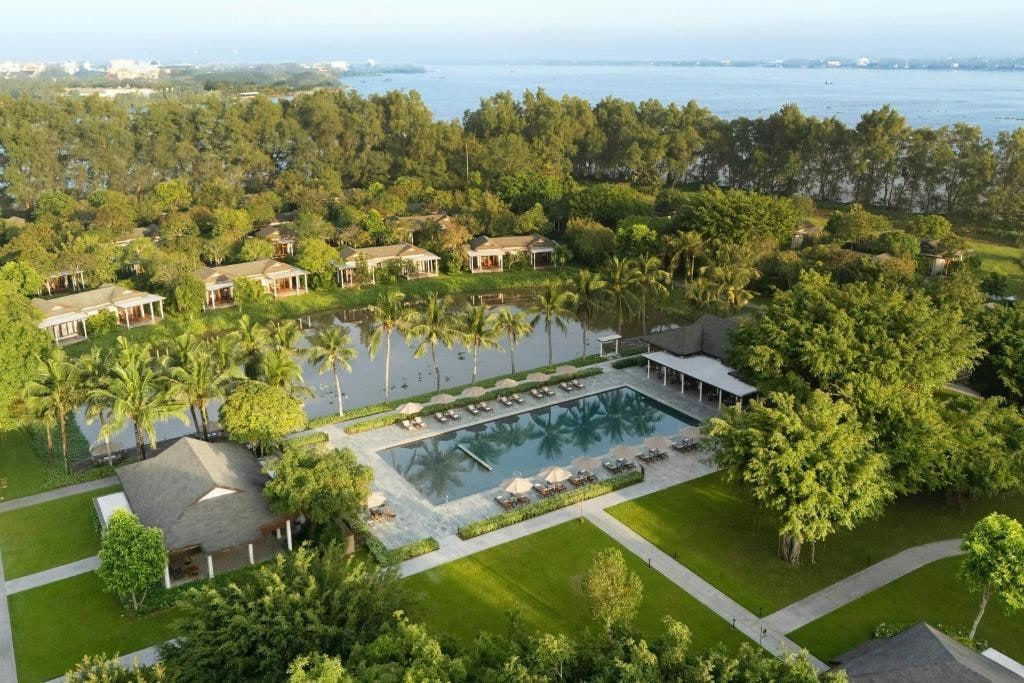 Legacy Mekong from above: the pool and the resort's pavilions among the gardens of Con Au islet, with the river behind