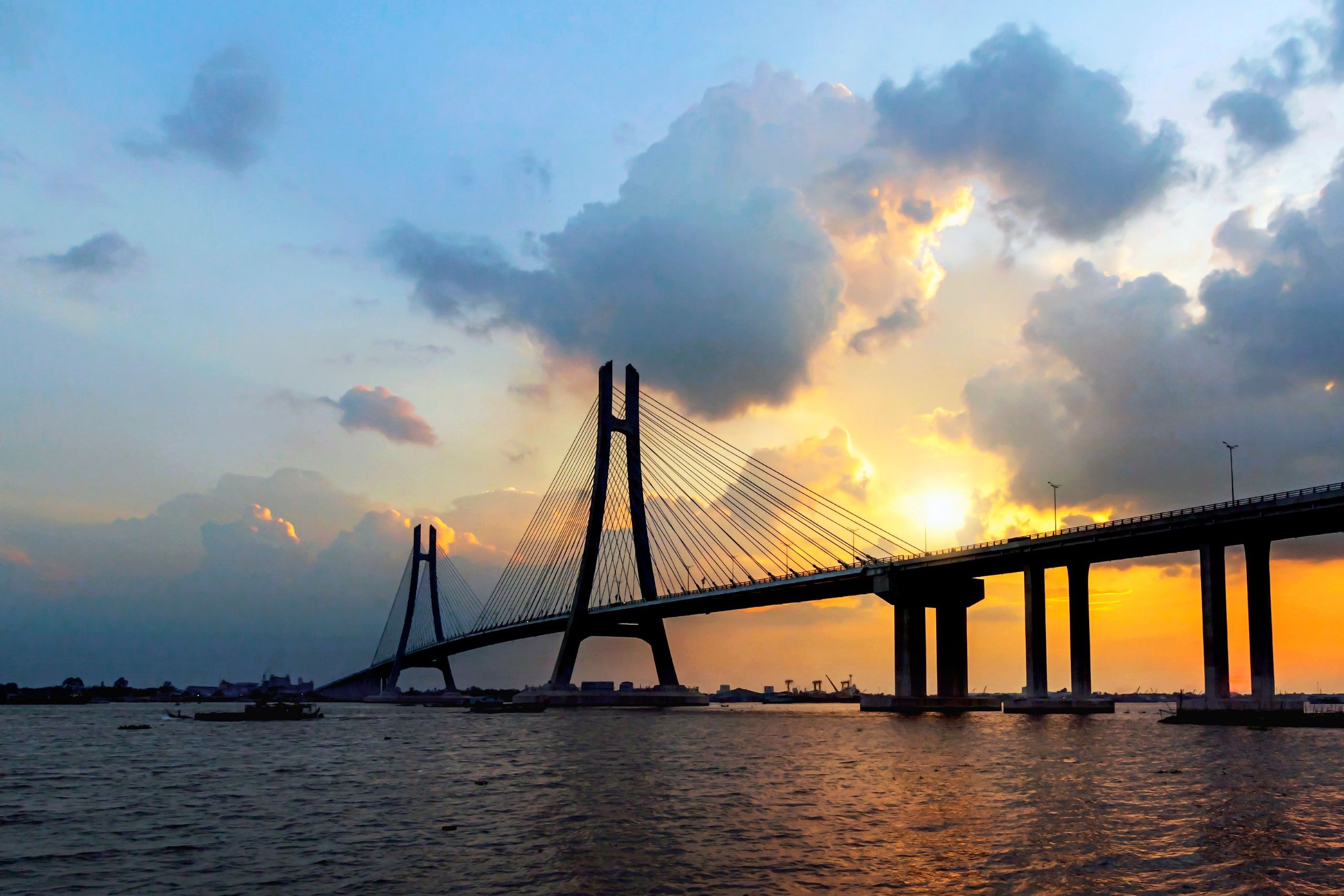 The Can Tho cable-stayed bridge silhouetted at sunset above the Hau River