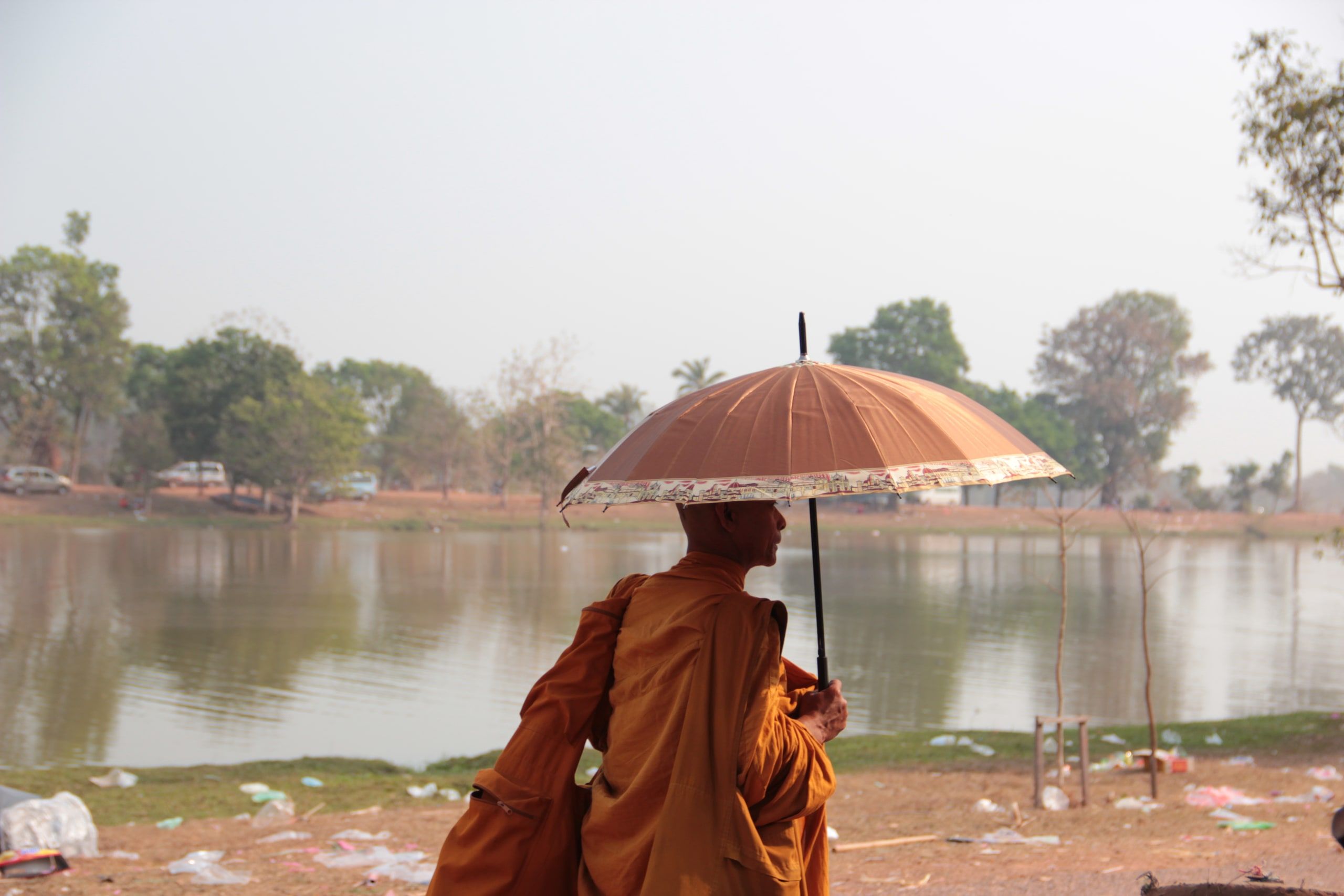 A monk under a parasol by the Vat Phou baray