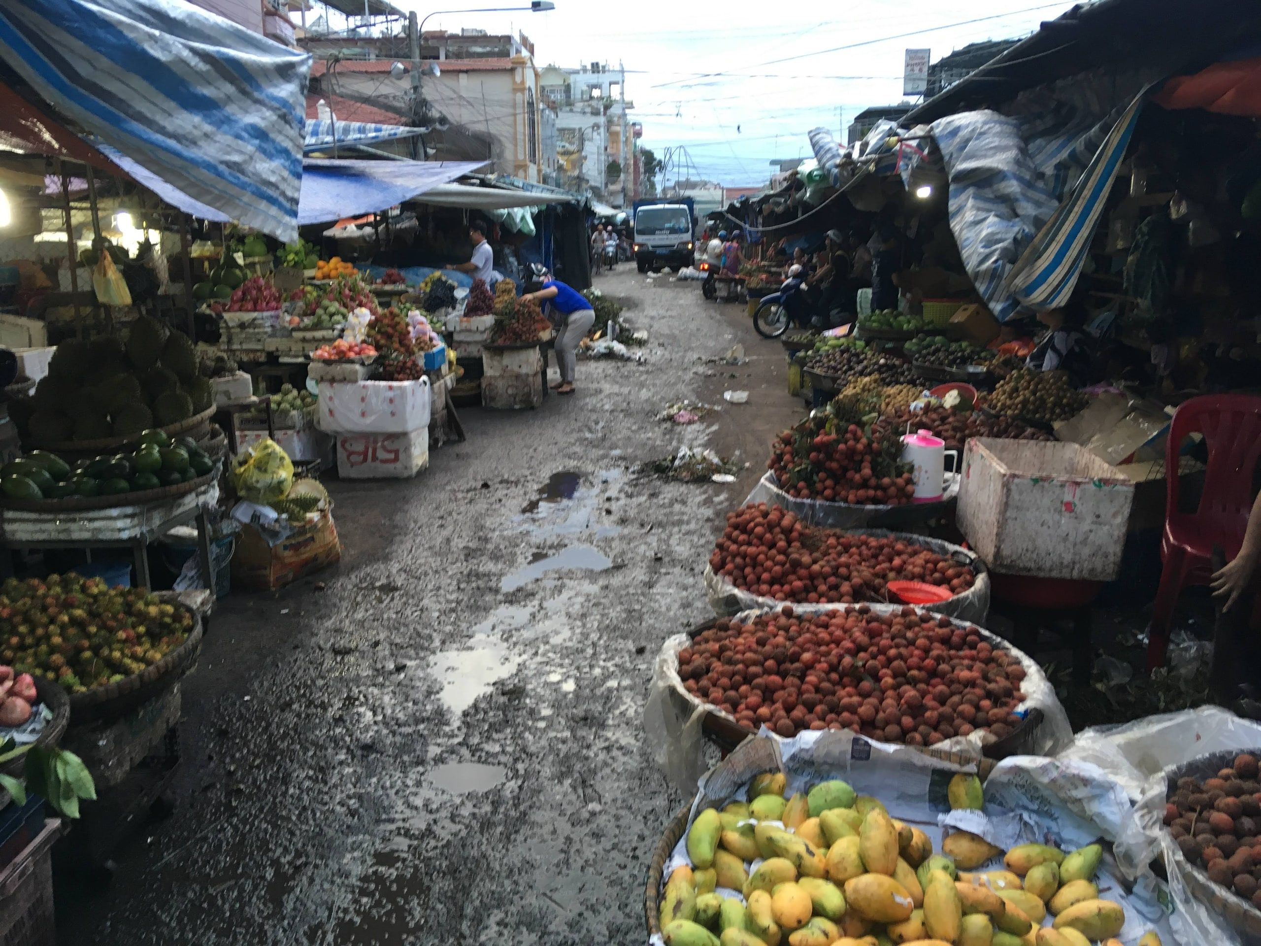 Des paniers de fruits sur les étals d'une ruelle du marché de Châu Đốc
