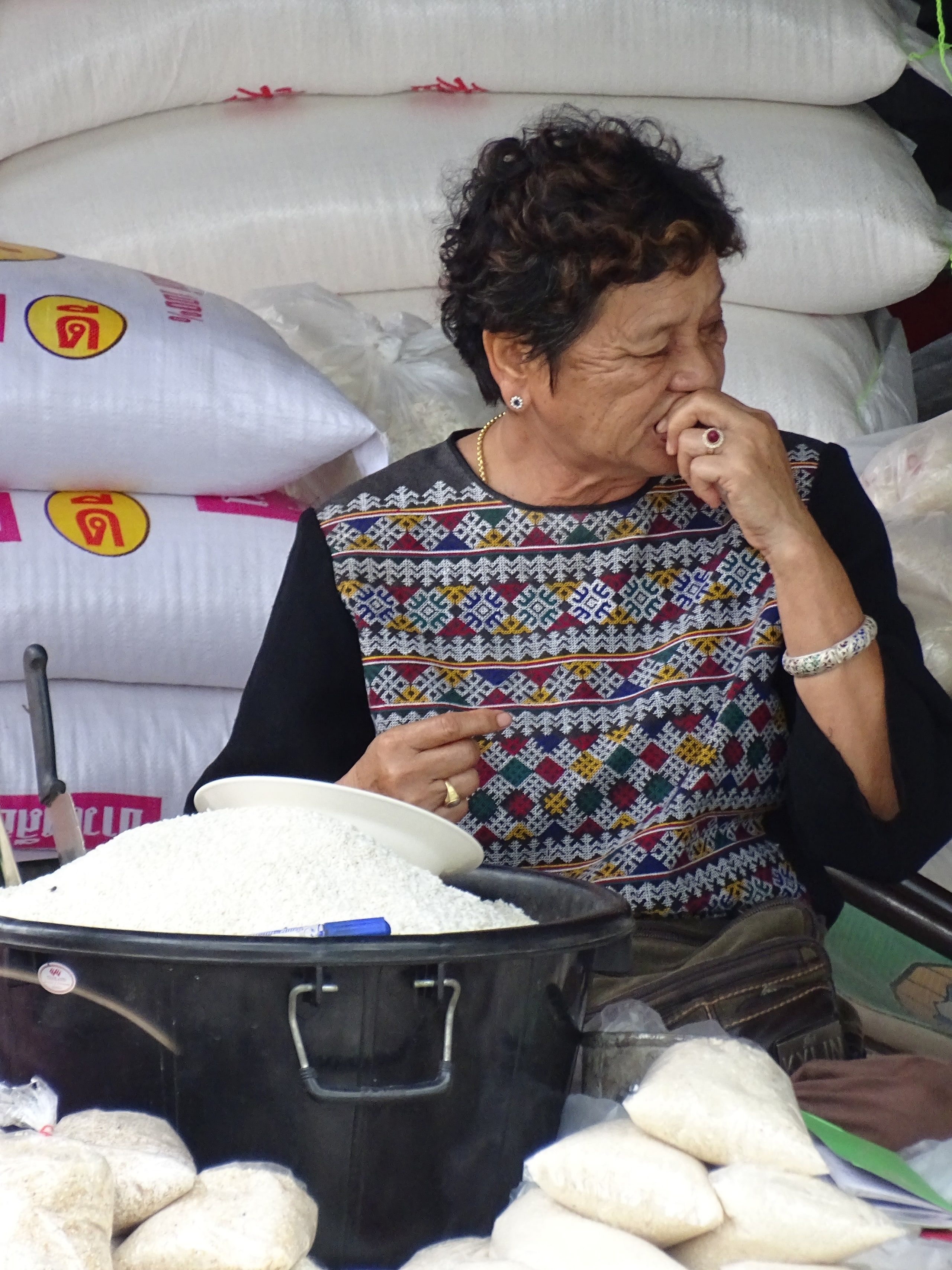 Une marchande au milieu de ses sacs de riz, au marché de Chiang Saen