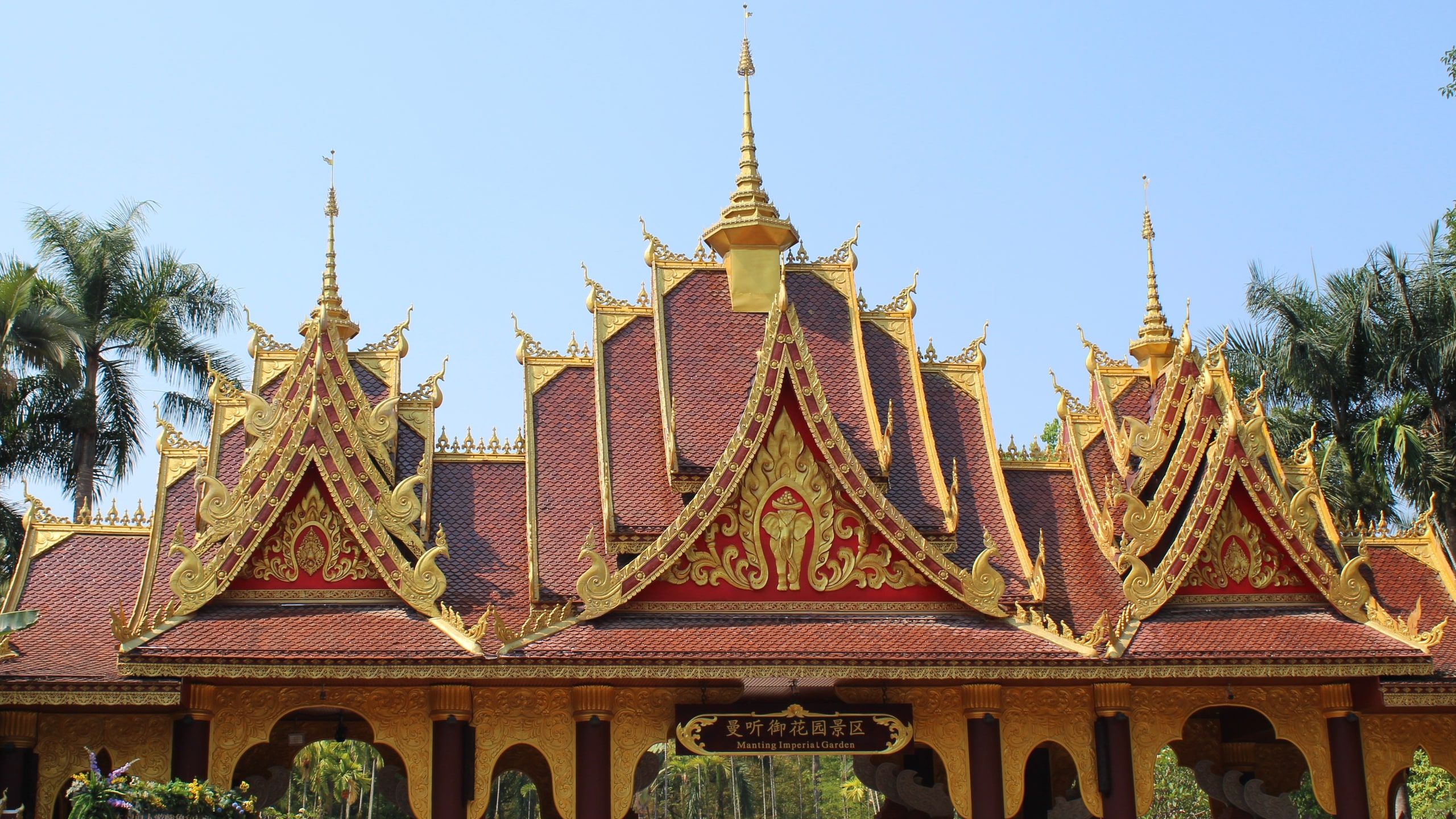 The gilded roofs of a pavilion in Manting Park under a blue sky