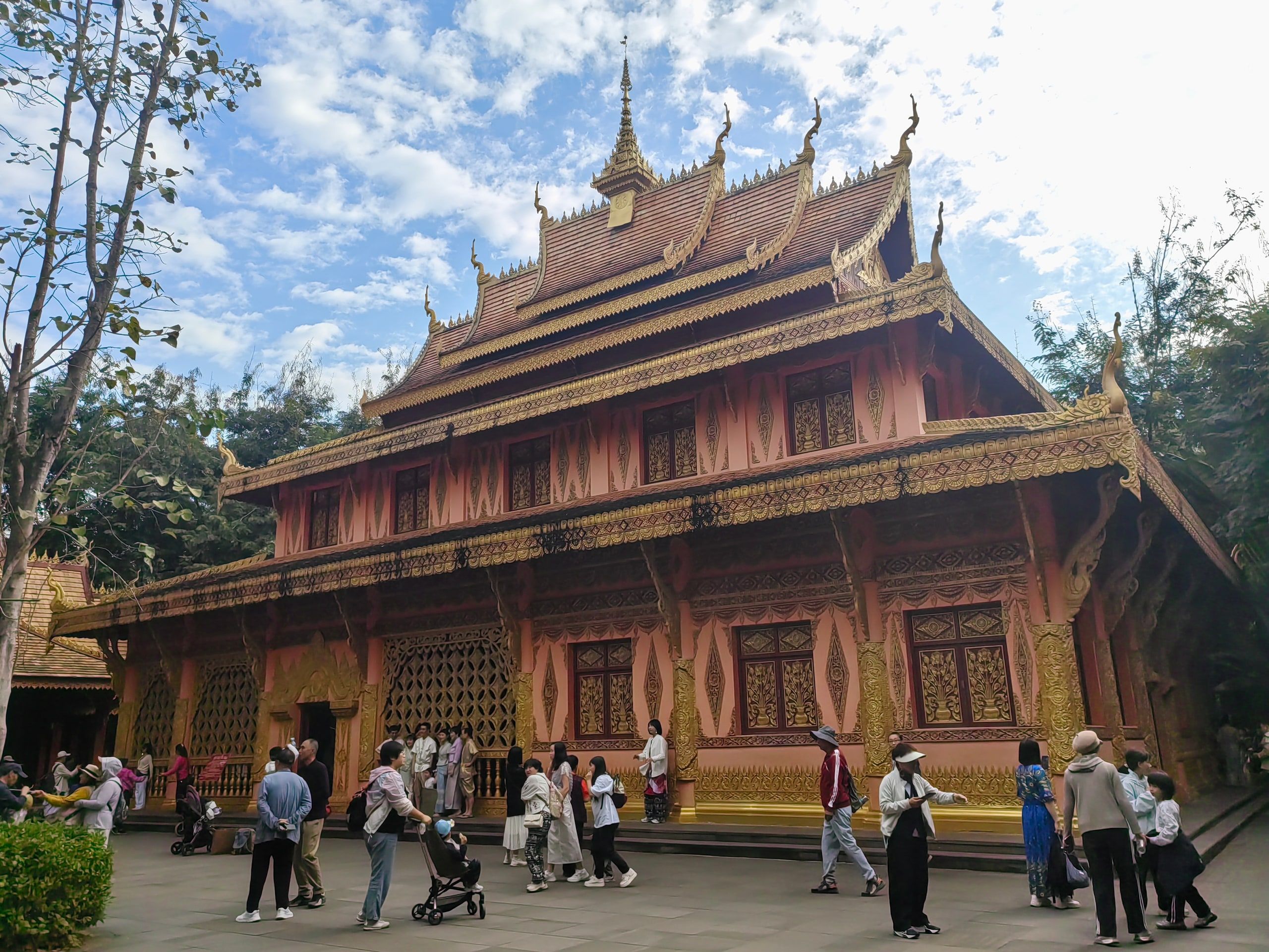 A wooden Dai temple in Manting Park, visitors at the entrance