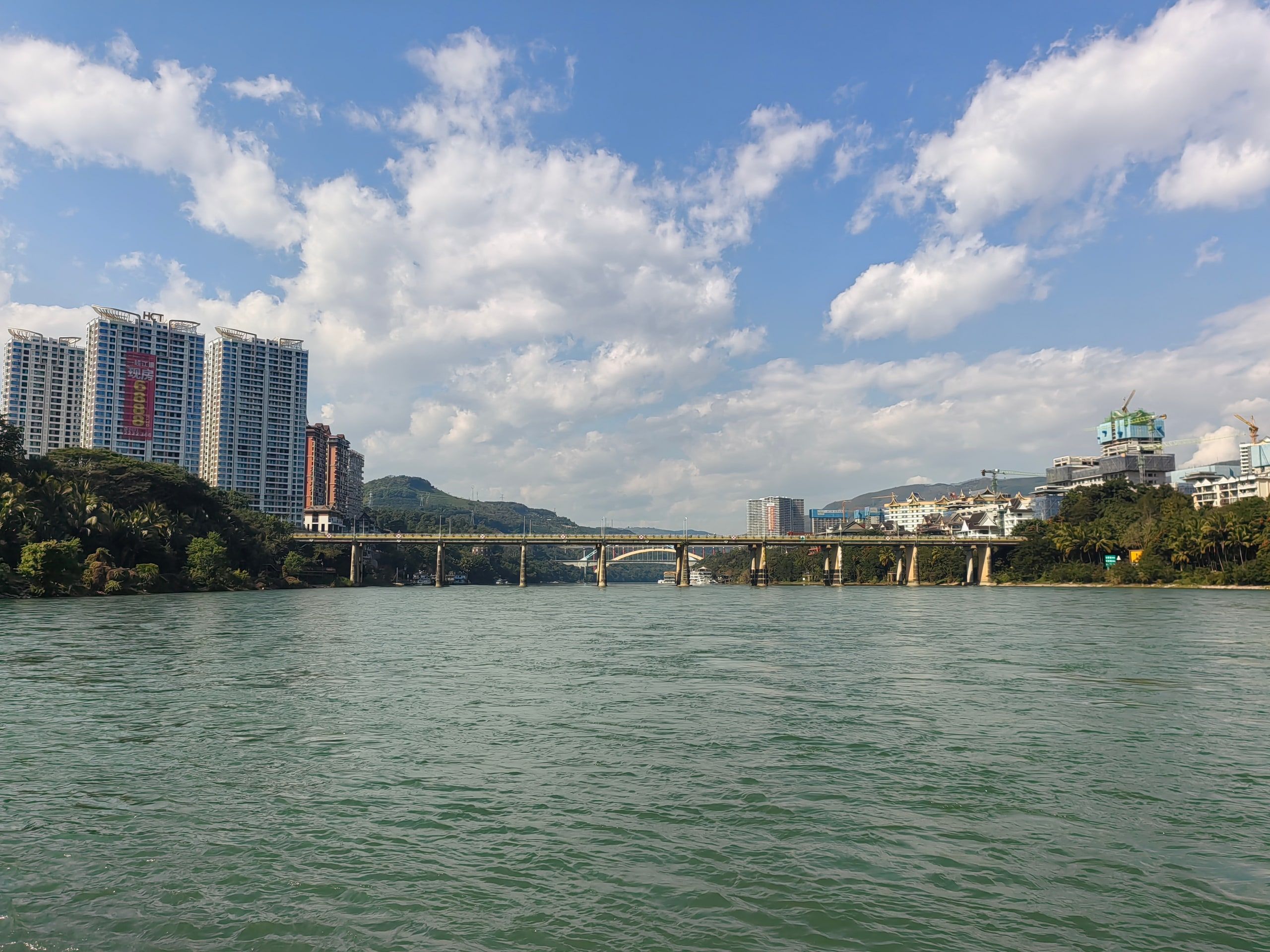 The Lancang and a Jinghong bridge under white clouds