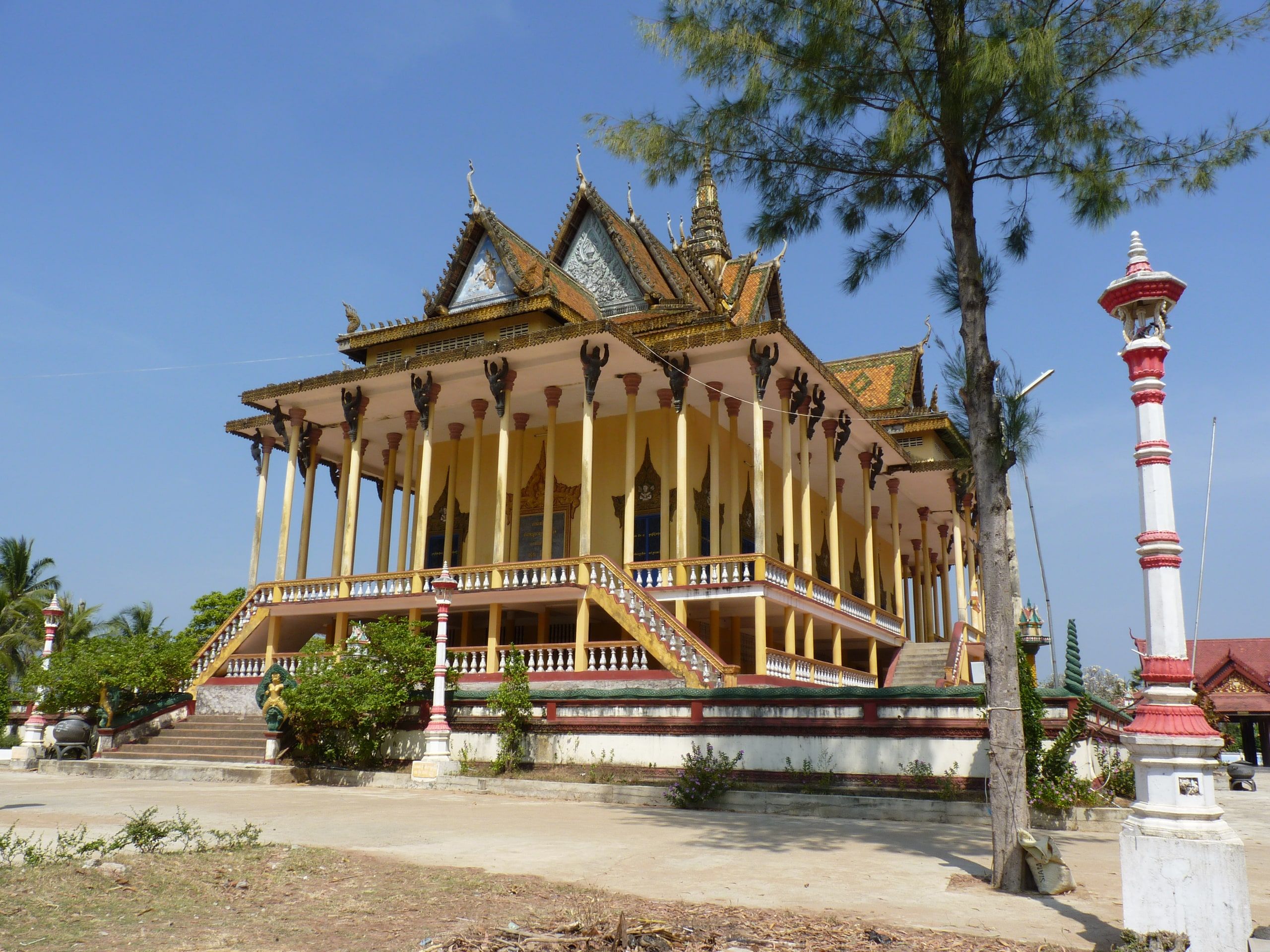 The hundred-column pagoda at Sambor, its gilded roofs and a red and white pole