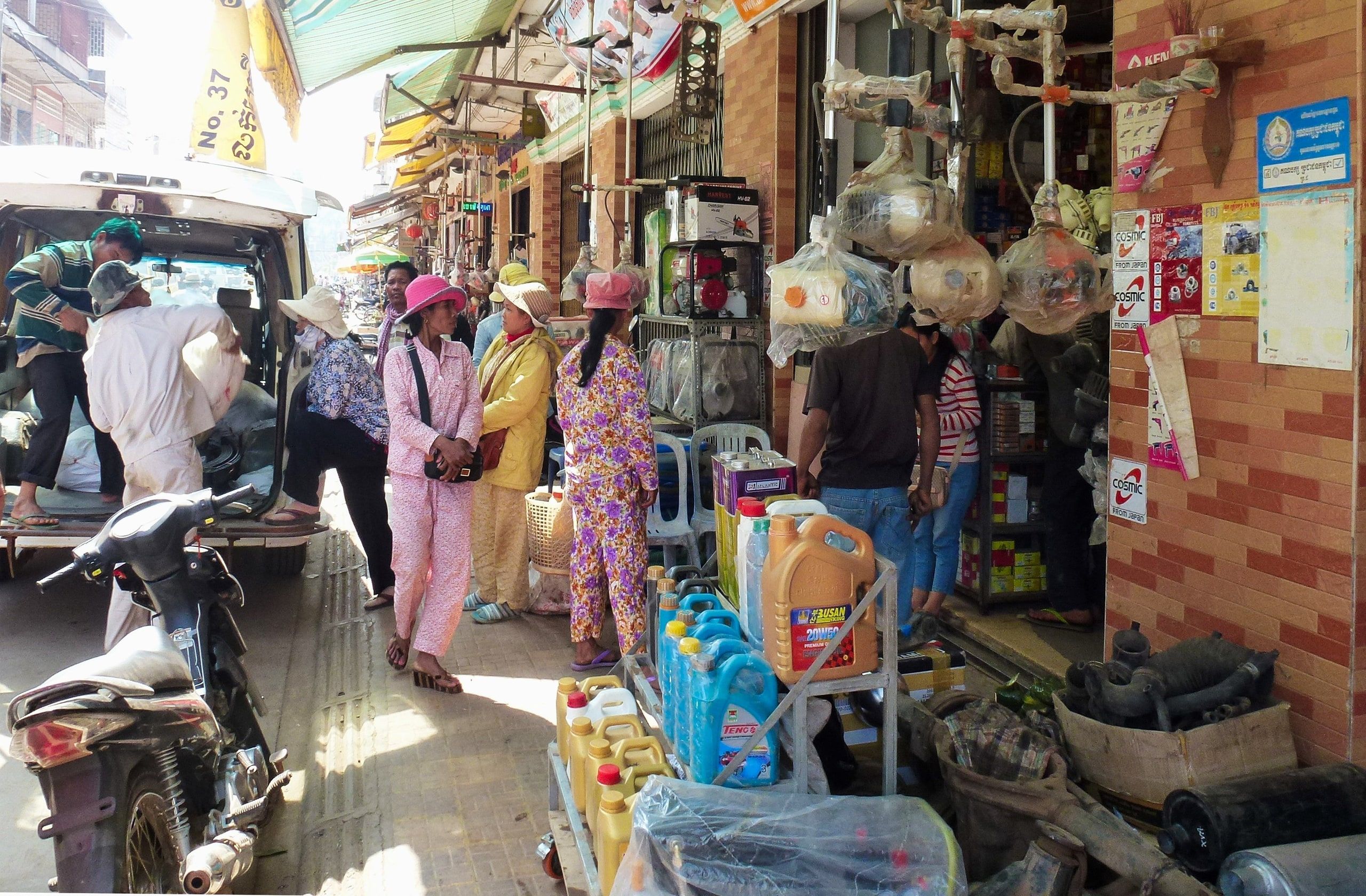 Shops and customers under the awnings of a Kratie shopping street
