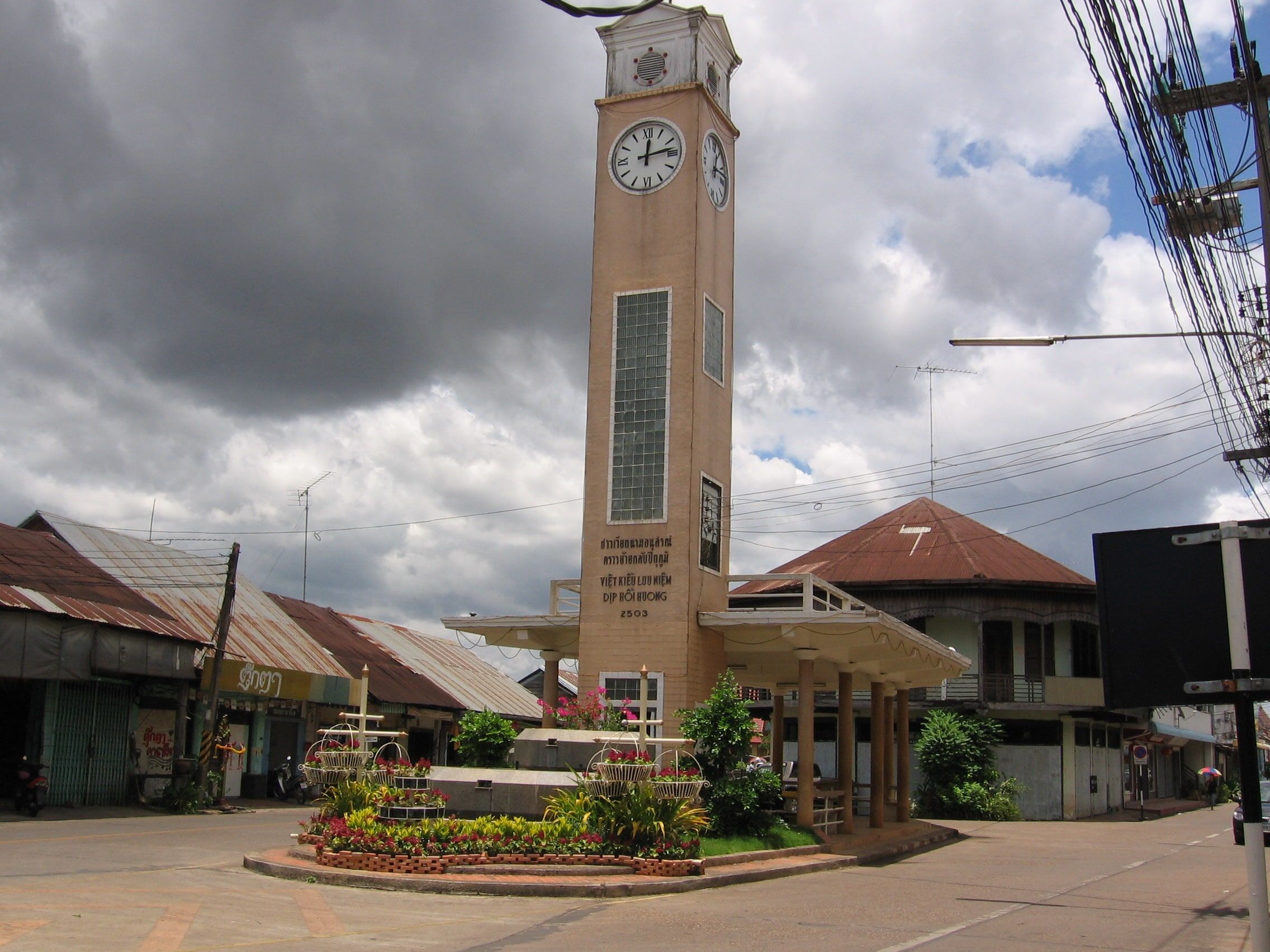 La tour de l'horloge de Nakhon Phanom, à un carrefour bordé de maisons basses