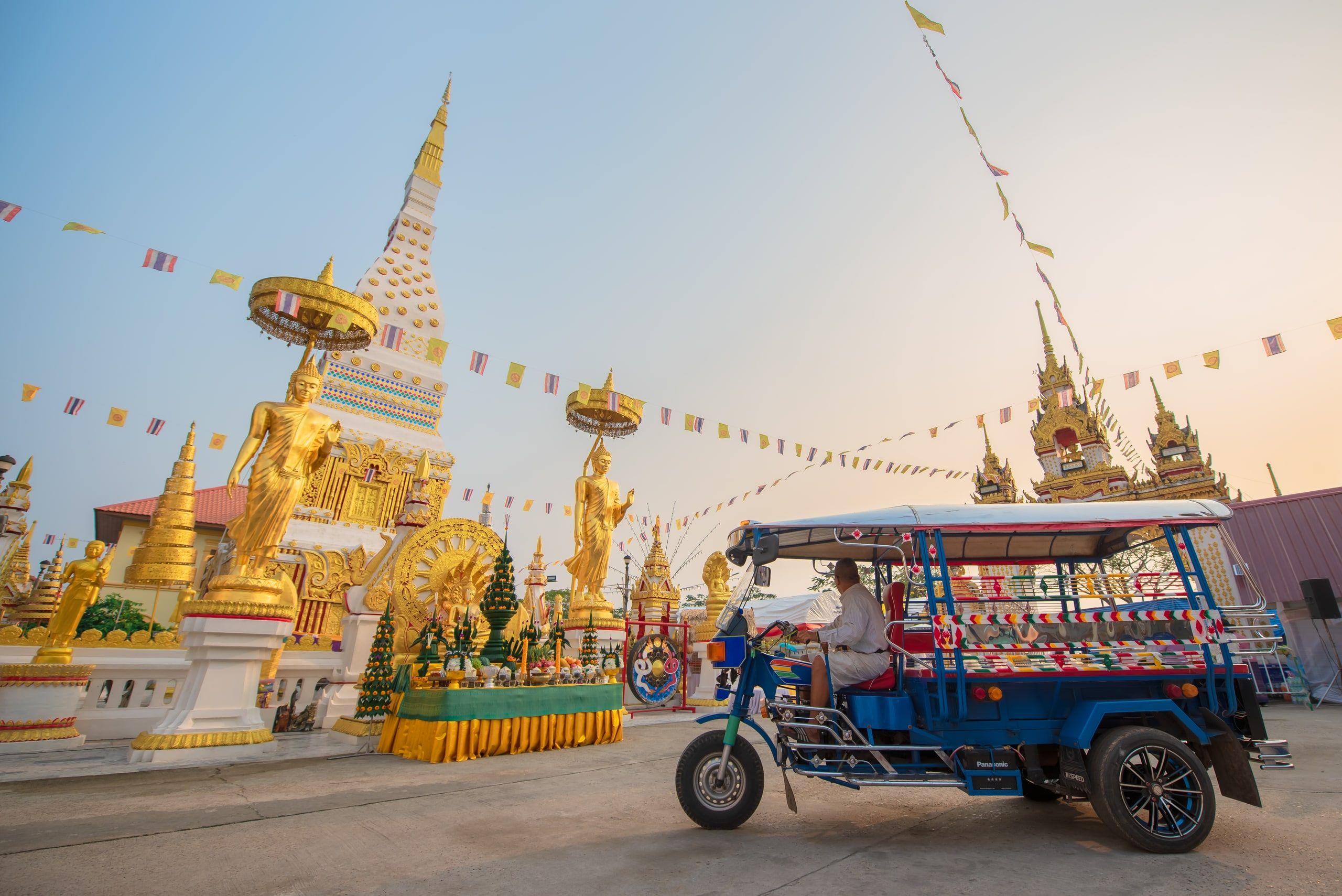 Le chedi du Wat Mahathat, ses statues dorées et un tuk-tuk décoré devant le temple