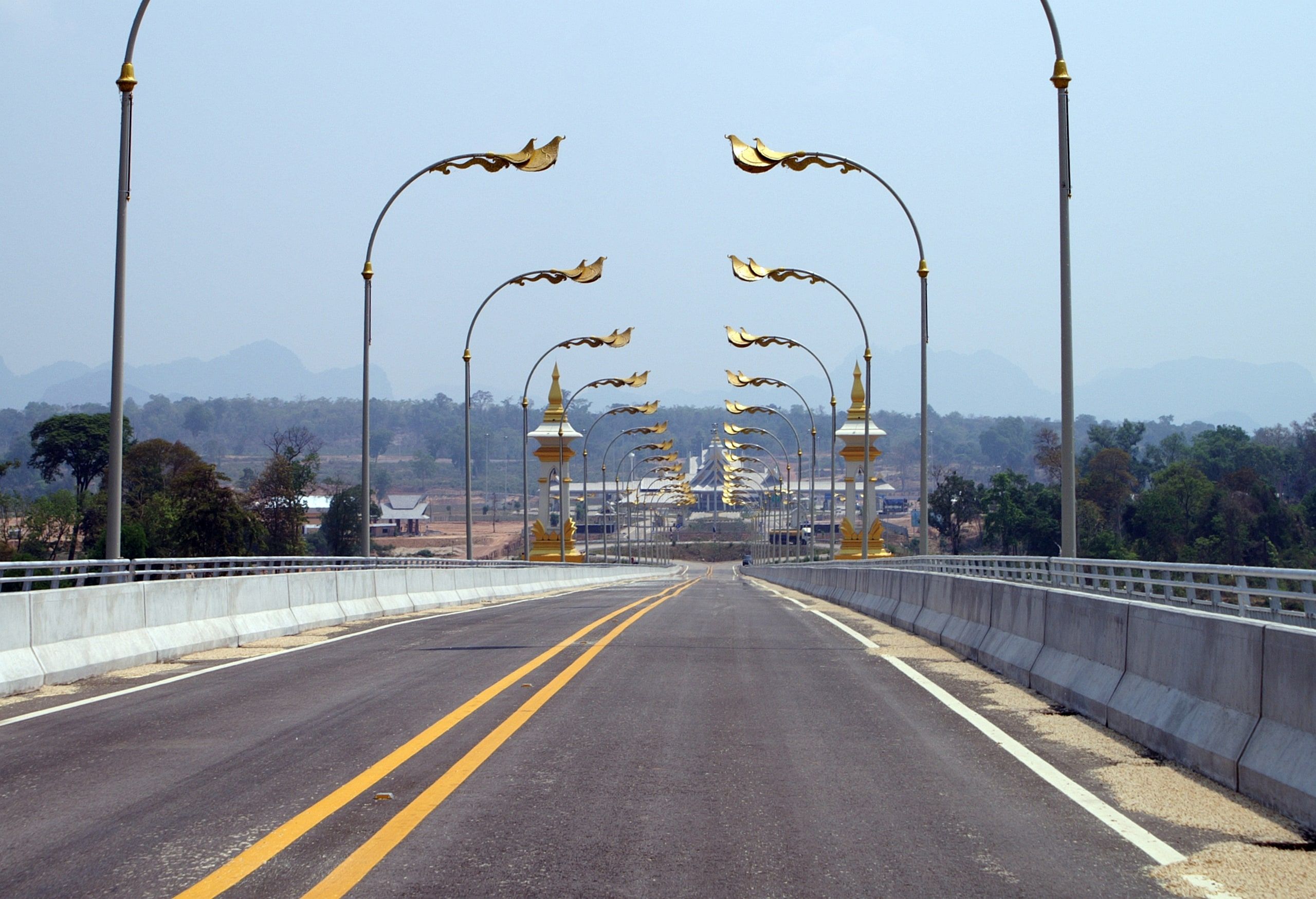 Le tablier du 3e pont de l'Amitié, ses lampadaires ornés et les reliefs du Laos au loin