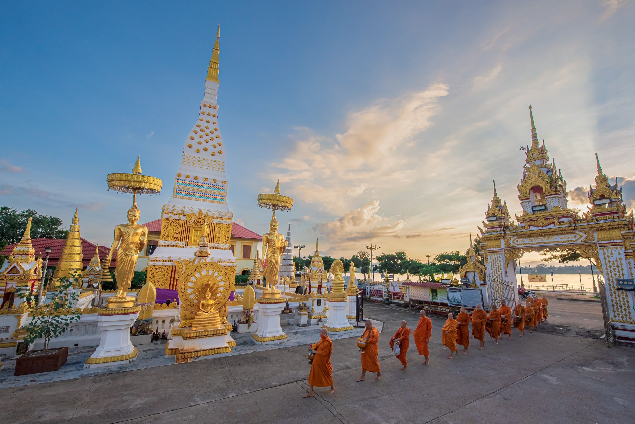 La quête des moines devant le chedi du Wat Mahathat, au bord du Mékong