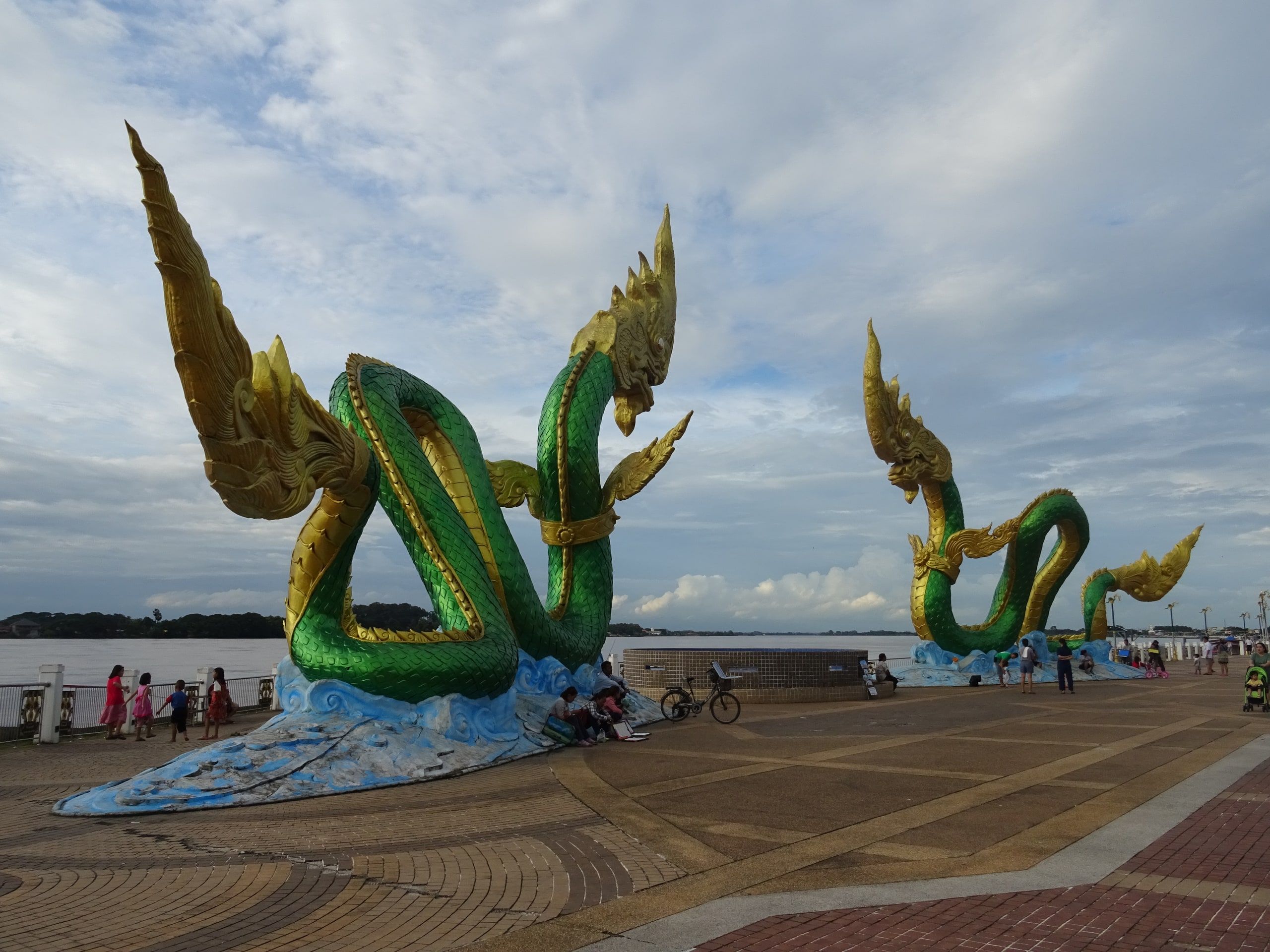 Des statues de nāga vert et or sur la promenade du Mékong, à Nong Khai