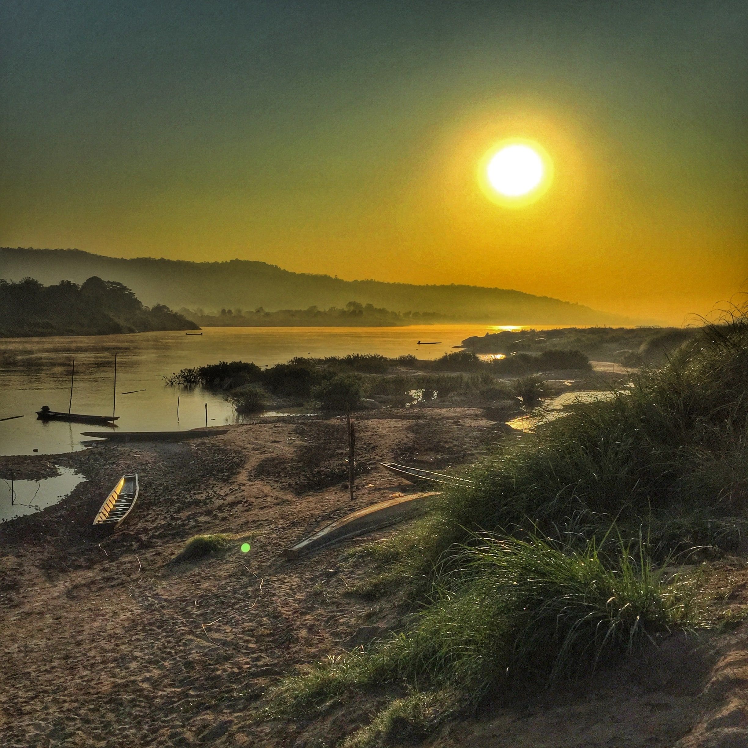 Low sun over the Mekong at Pha Tang, Sangkhom district, a boat on the sand