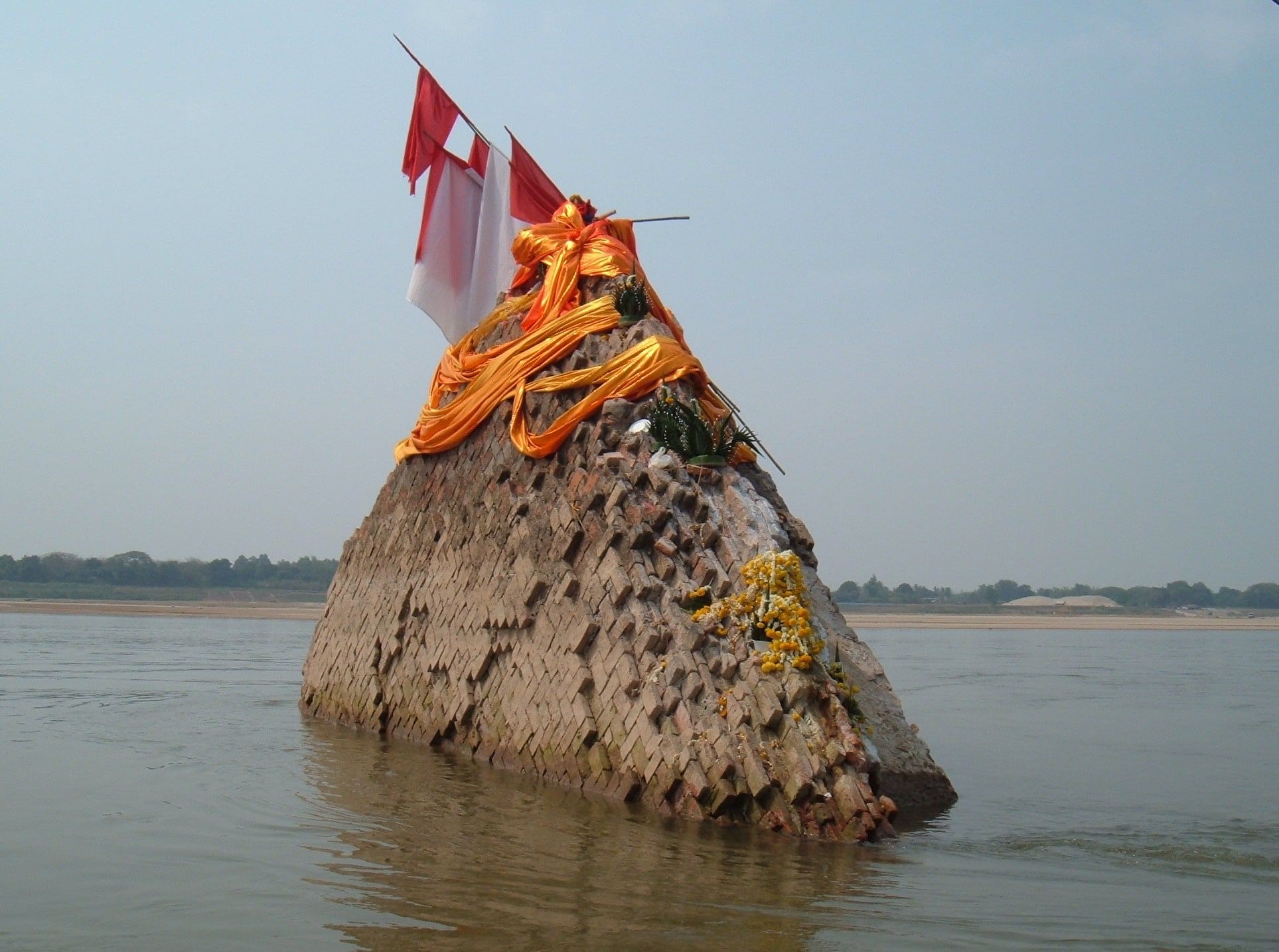 Phra That Nong Khai, the collapsed chedi in the middle of the Mekong, draped in orange