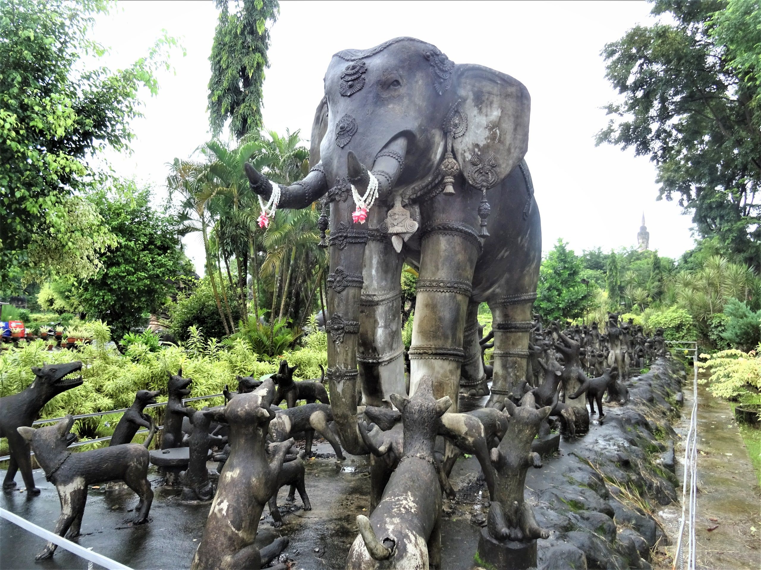 An elephant surrounded by dogs, concrete sculptures at Sala Keoku