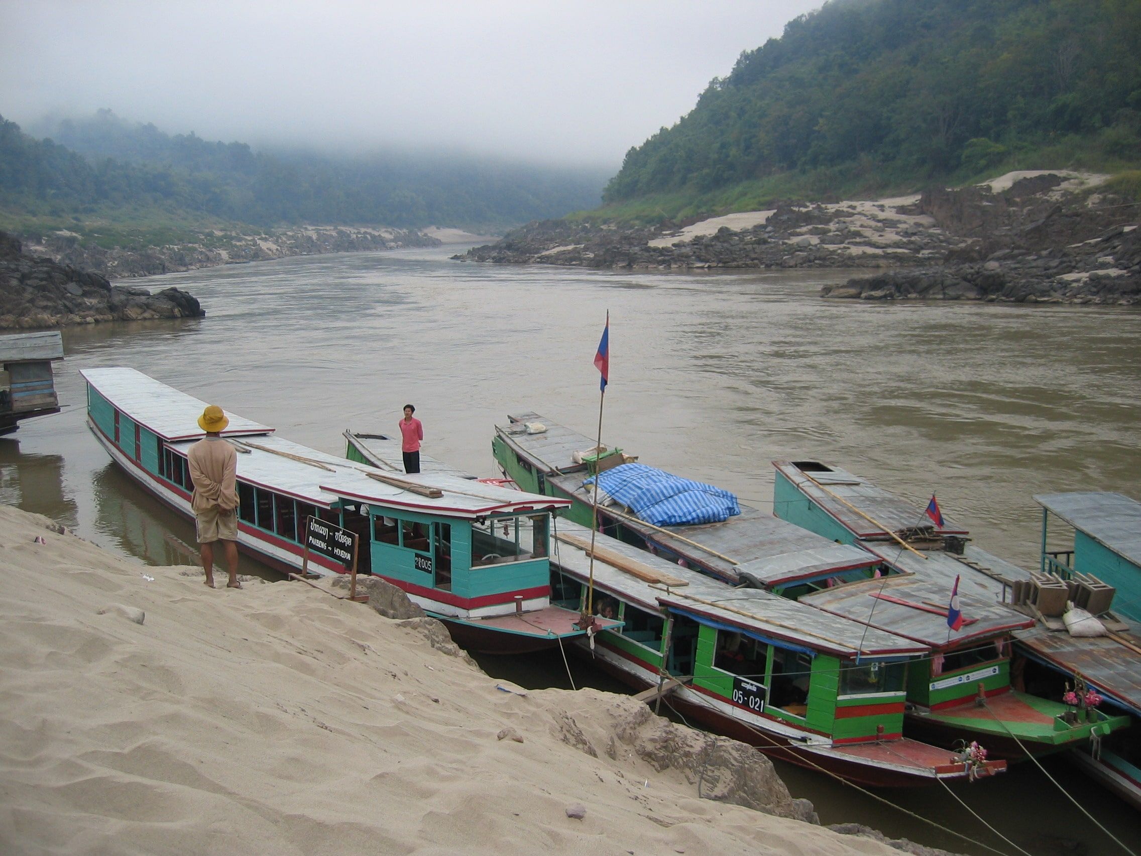 Slow boats moored on the sandy bank of the Mekong at Pakbeng