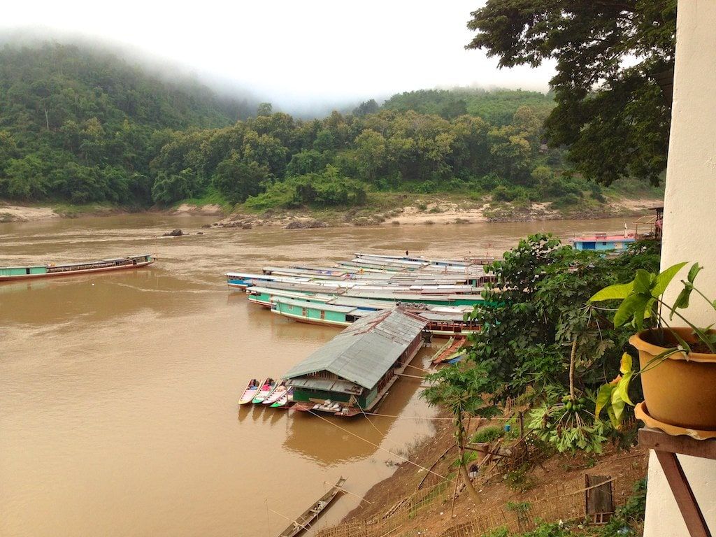 Boats moored below Pakbeng, seen from a balcony on a misty morning
