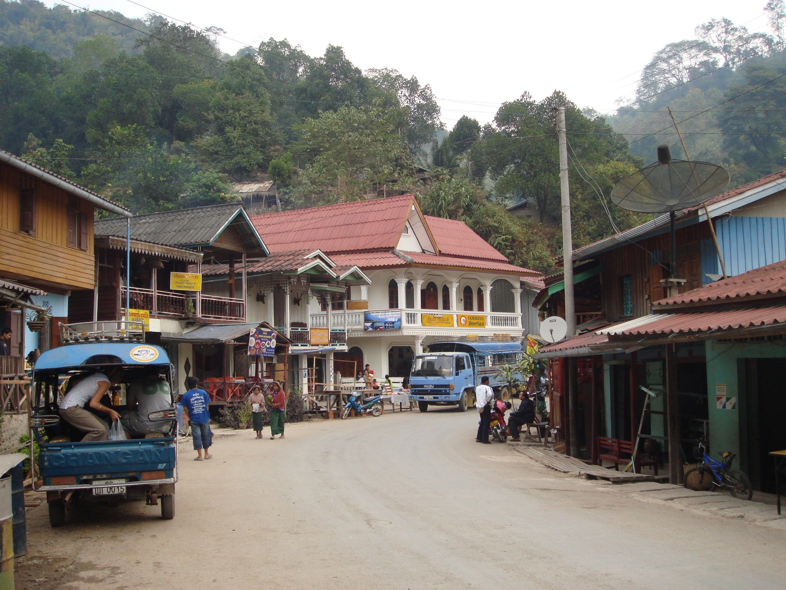 Pakbeng's main street, its wooden houses and a parked tuk-tuk