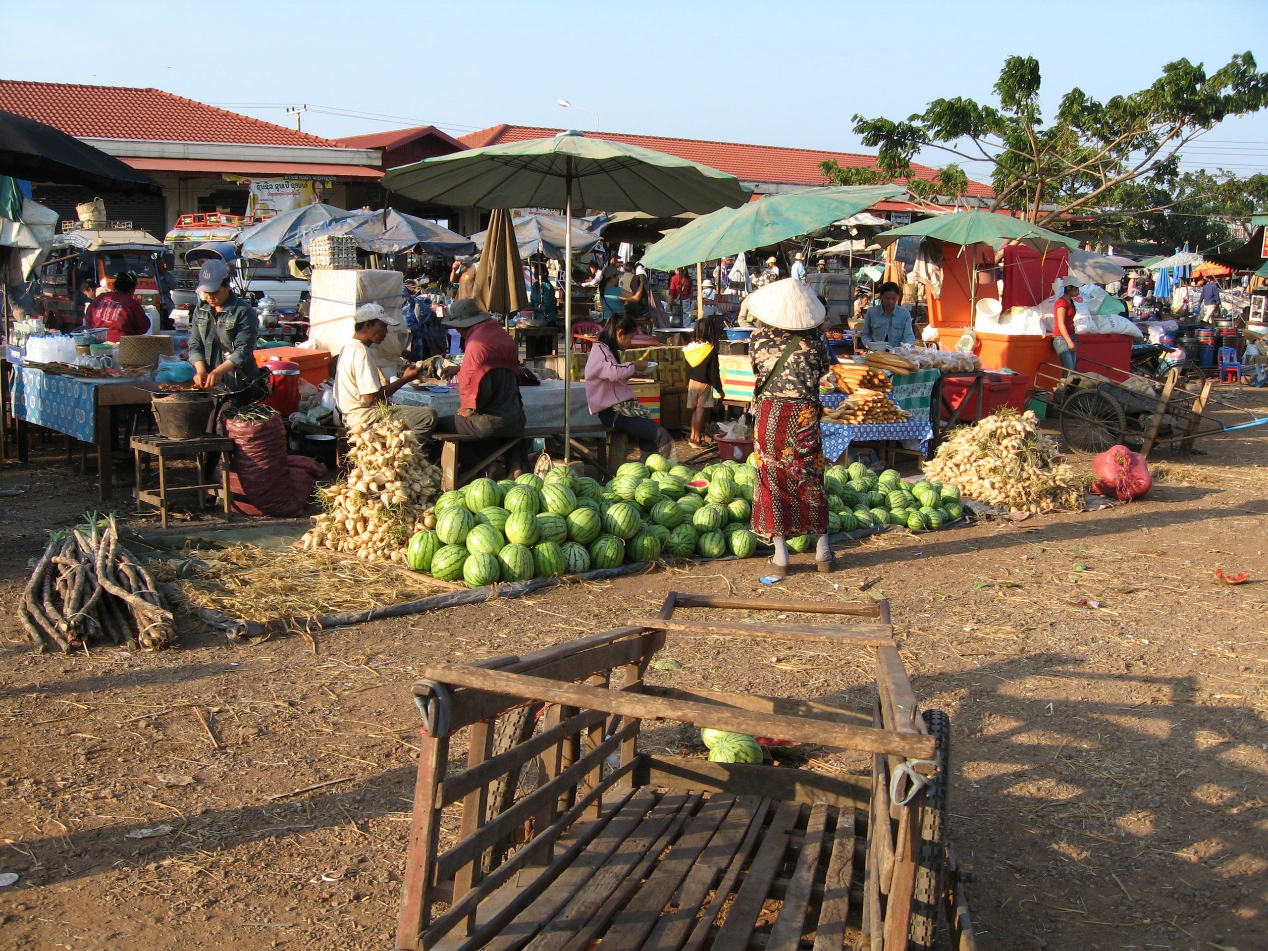 Watermelons and stalls under umbrellas at the Pakse market