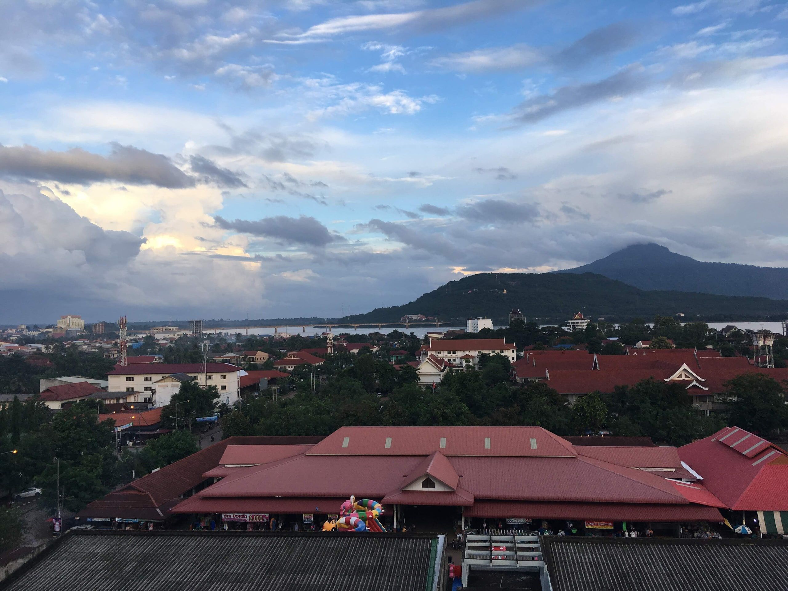 Les toits de Paksé vus d'une terrasse, des montagnes à l'horizon