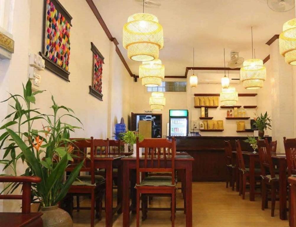 La salle du restaurant du Sanga Hostel, ses lampes en bambou et ses tables en bois