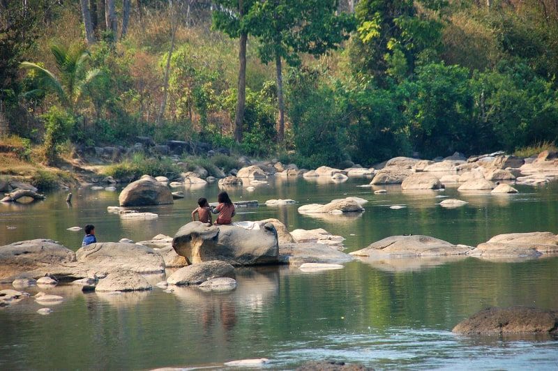 Children on the river rocks at Tad Lo, on the Bolaven Plateau