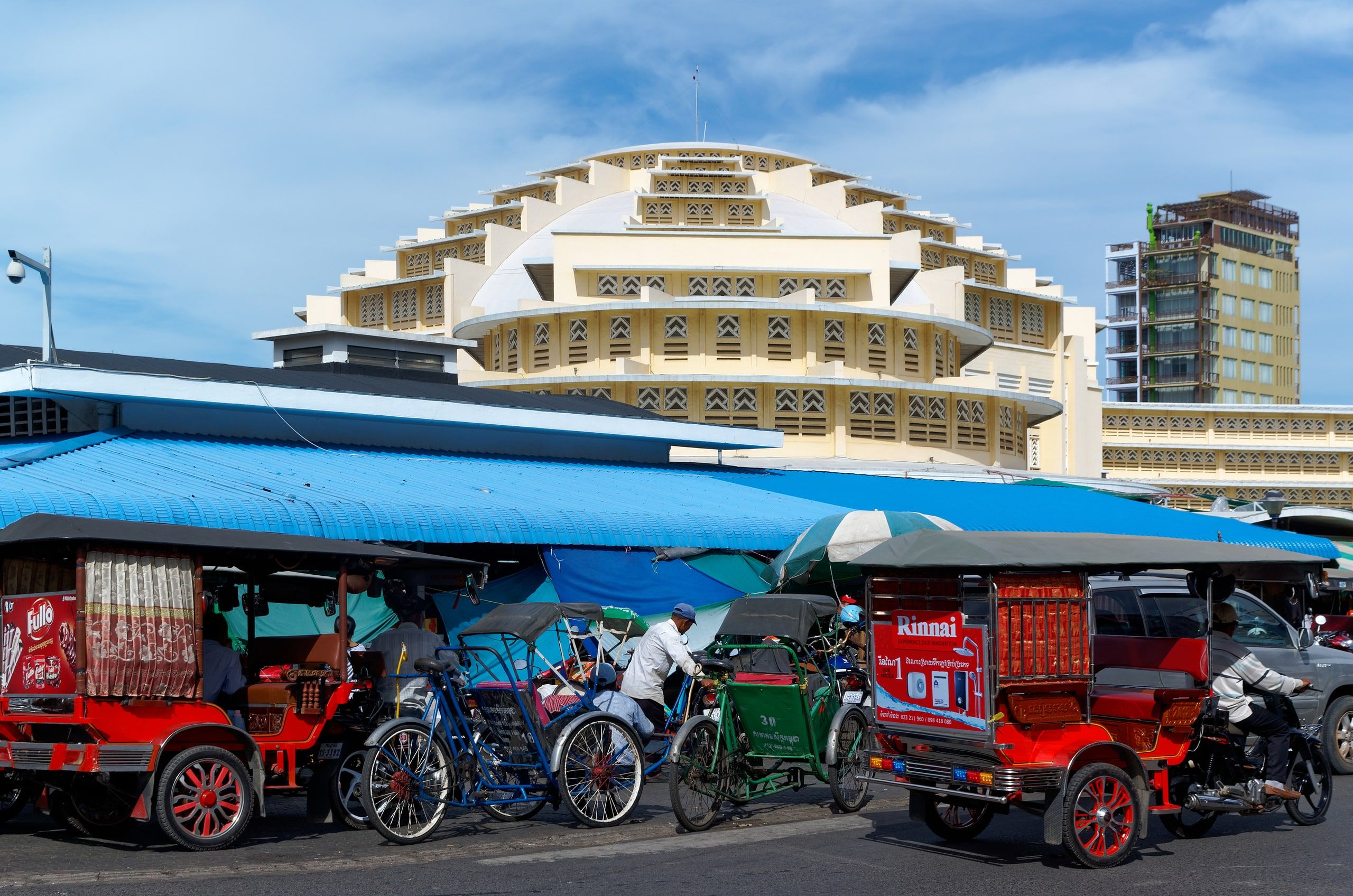 The art deco dome of the Central Market, with tuk-tuks and cyclos parked in front