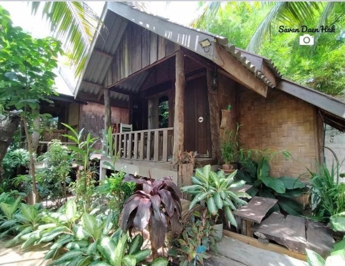 A wood and bamboo bungalow at Sala Thongyon, in a tropical garden
