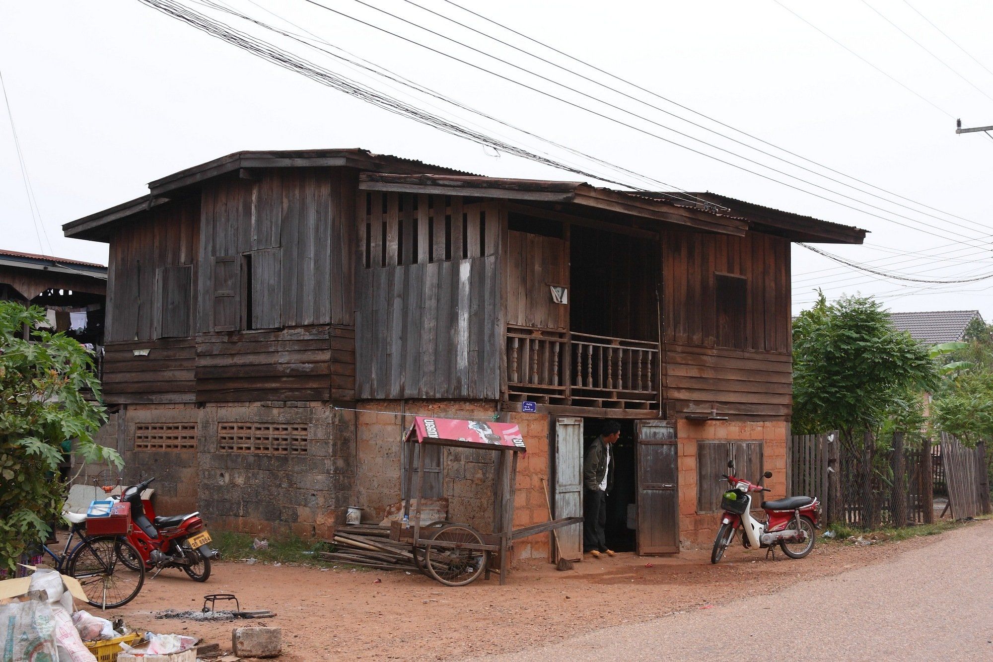A two-story wooden house with a balcony, on a Savannakhet street
