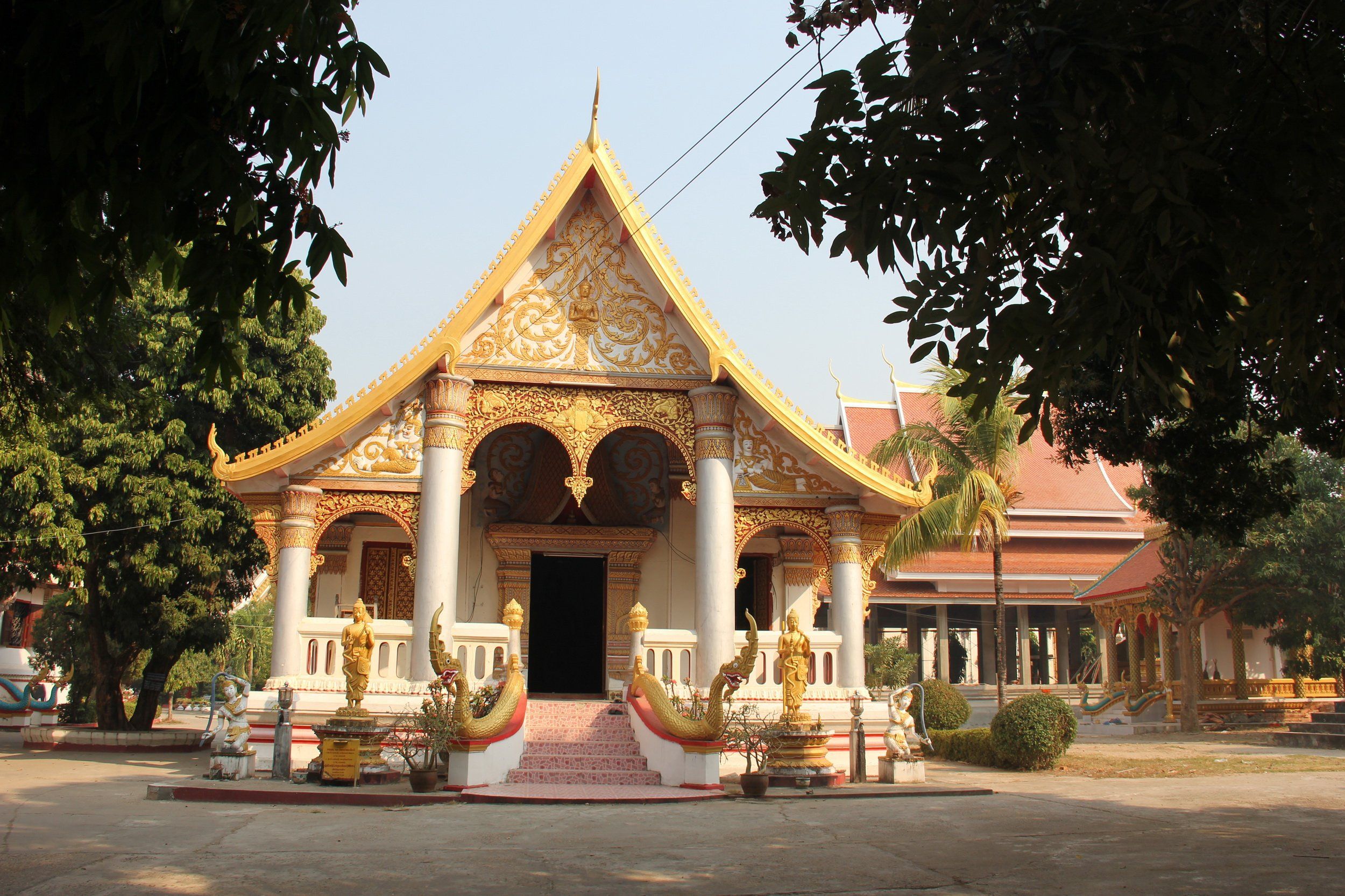 A gilded hall of Wat Sainyaphum, framed by trees