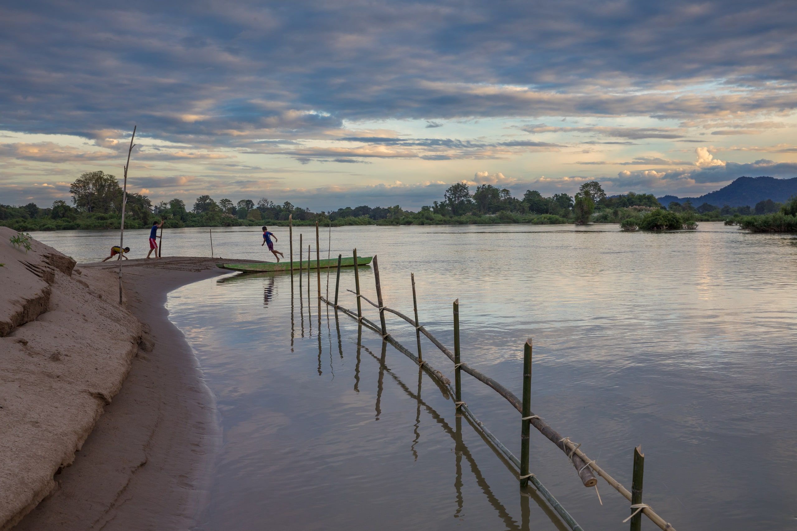 Children playing at sunset on a bank of the Mekong