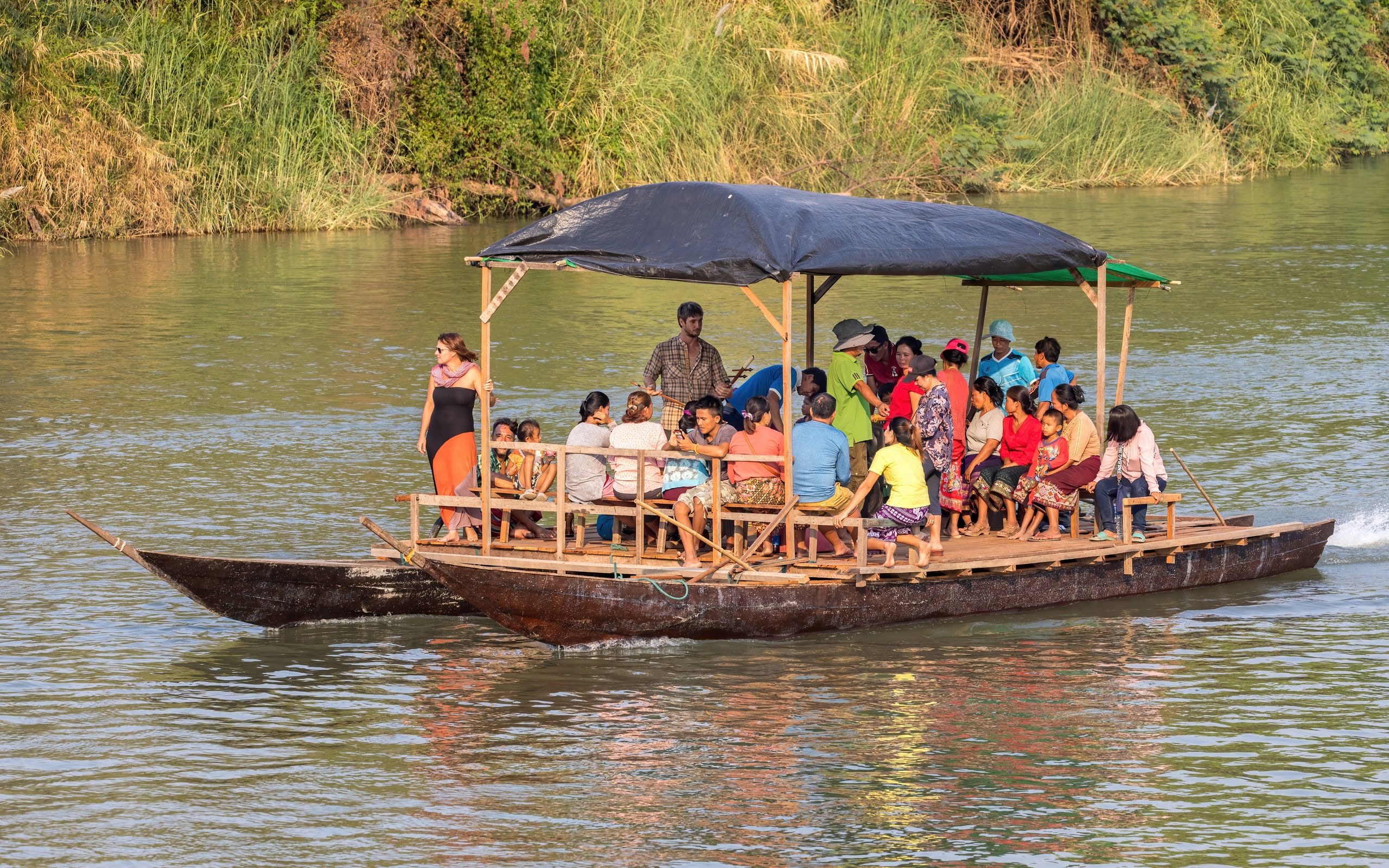 A double-hulled boat carrying passengers on the Mekong at Don Det