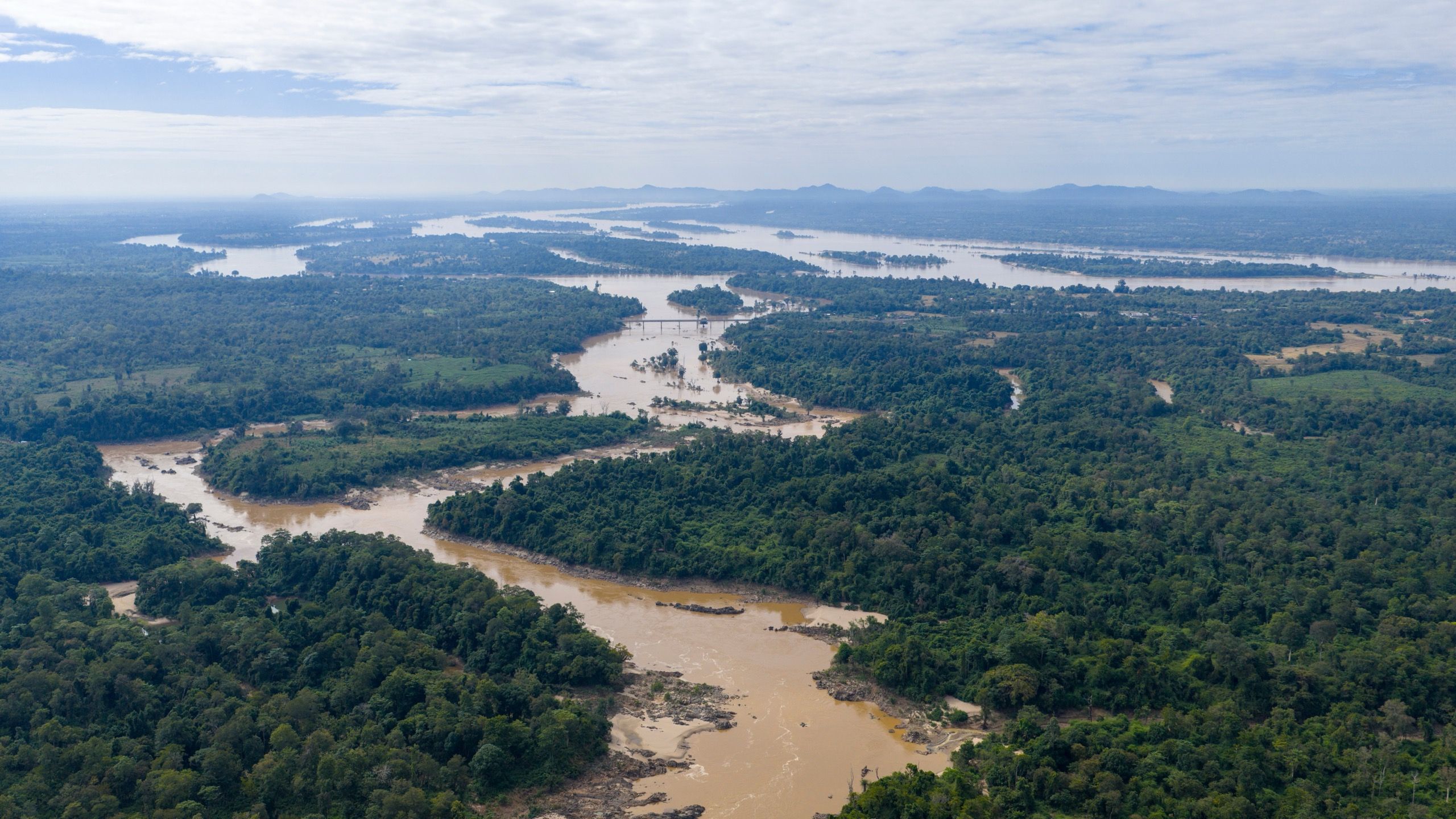 The Mekong split into many channels between forested islands, seen from the air, in southern Laos