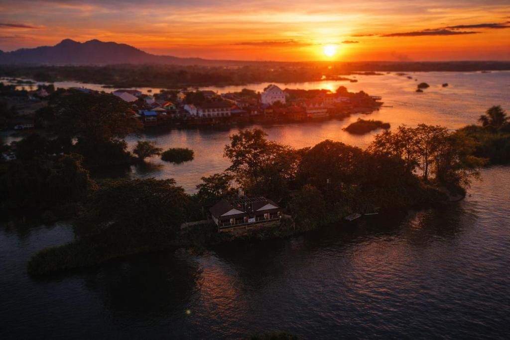 Don Falang island at sunset, a bungalow by the water among the trees