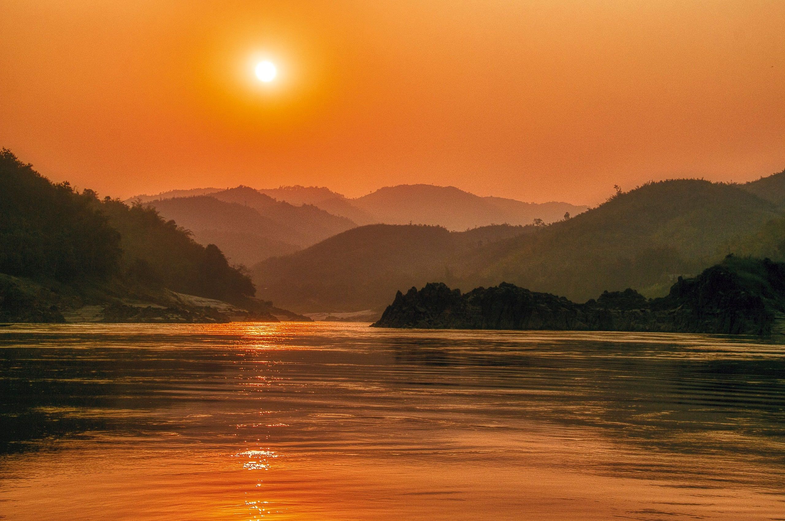 The Mekong at sunset between wooded hills in Bokeo province, Laos, on the slow boat route