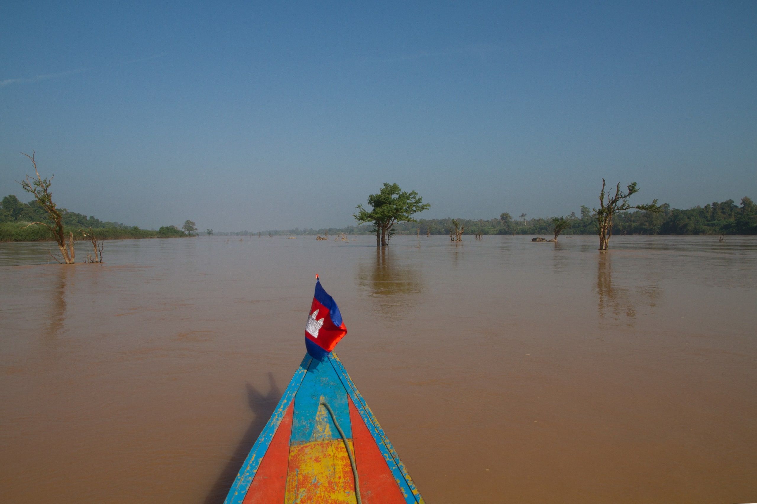 The bow of a boat flying the Cambodian flag on the flooded Mekong, north of Stung Treng