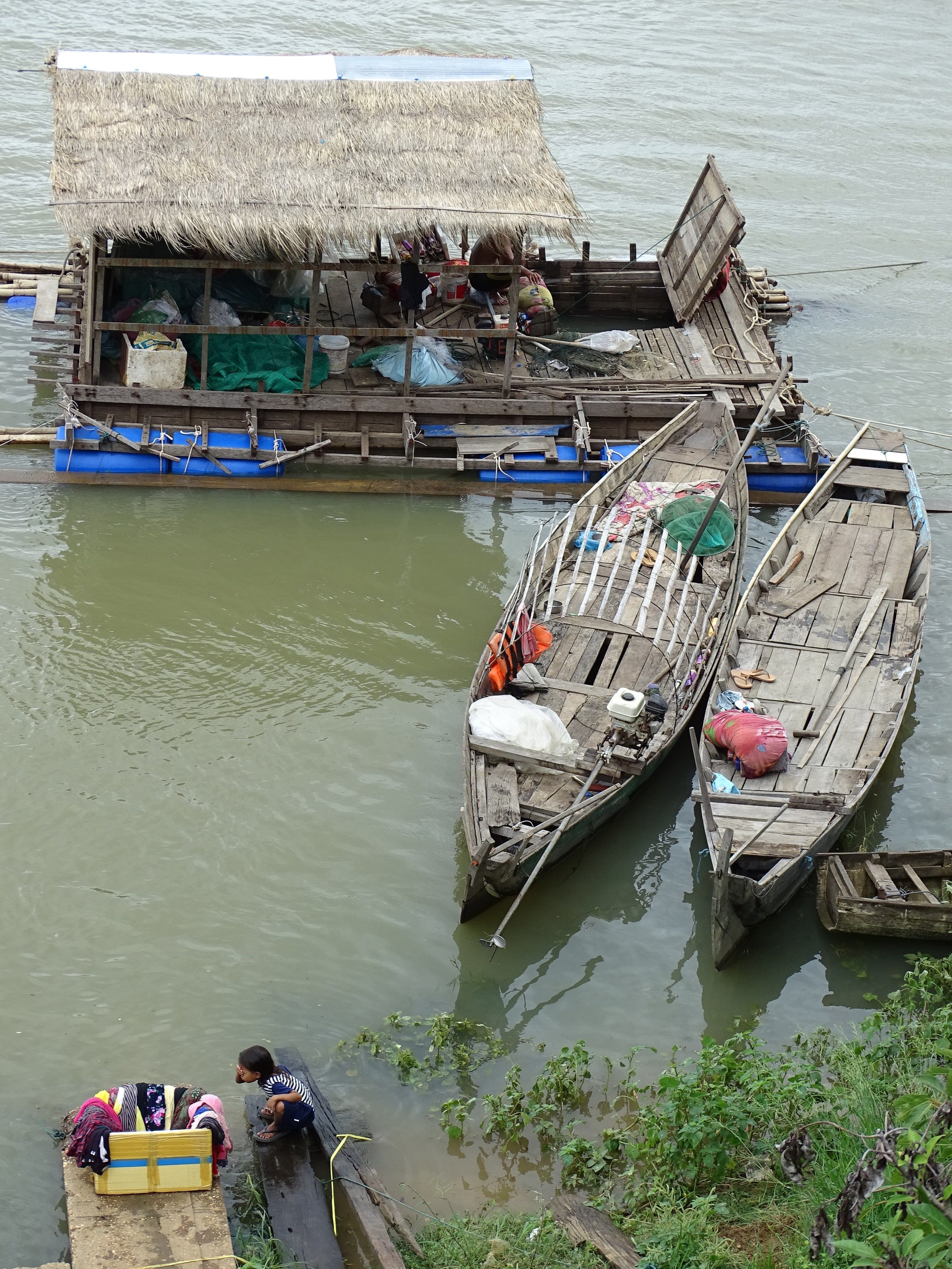 Des barques de pêche amarrées près d'une maison flottante sur la Sékong