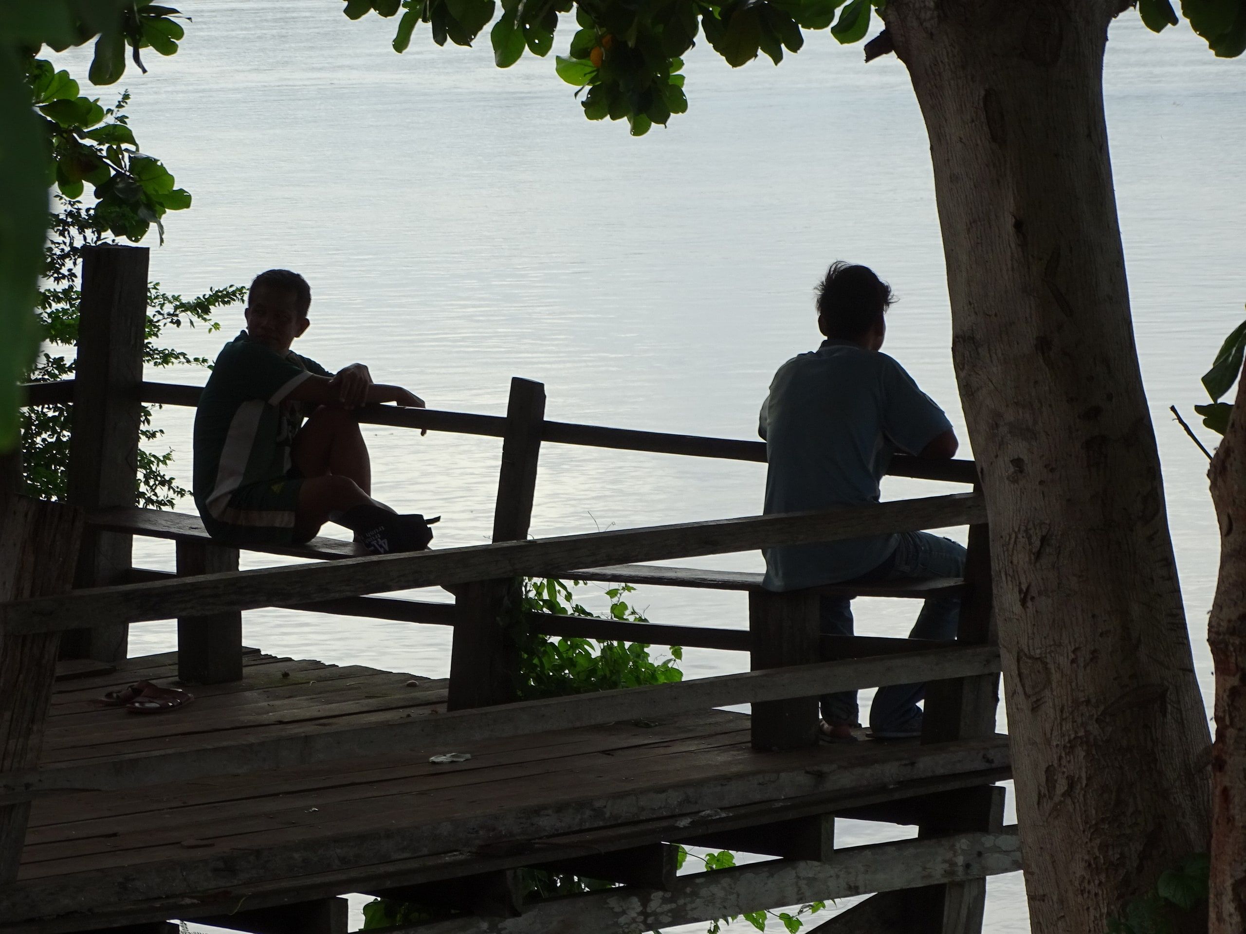 Deux hommes sur une terrasse de bois regardent la Sékong, à Stung Treng
