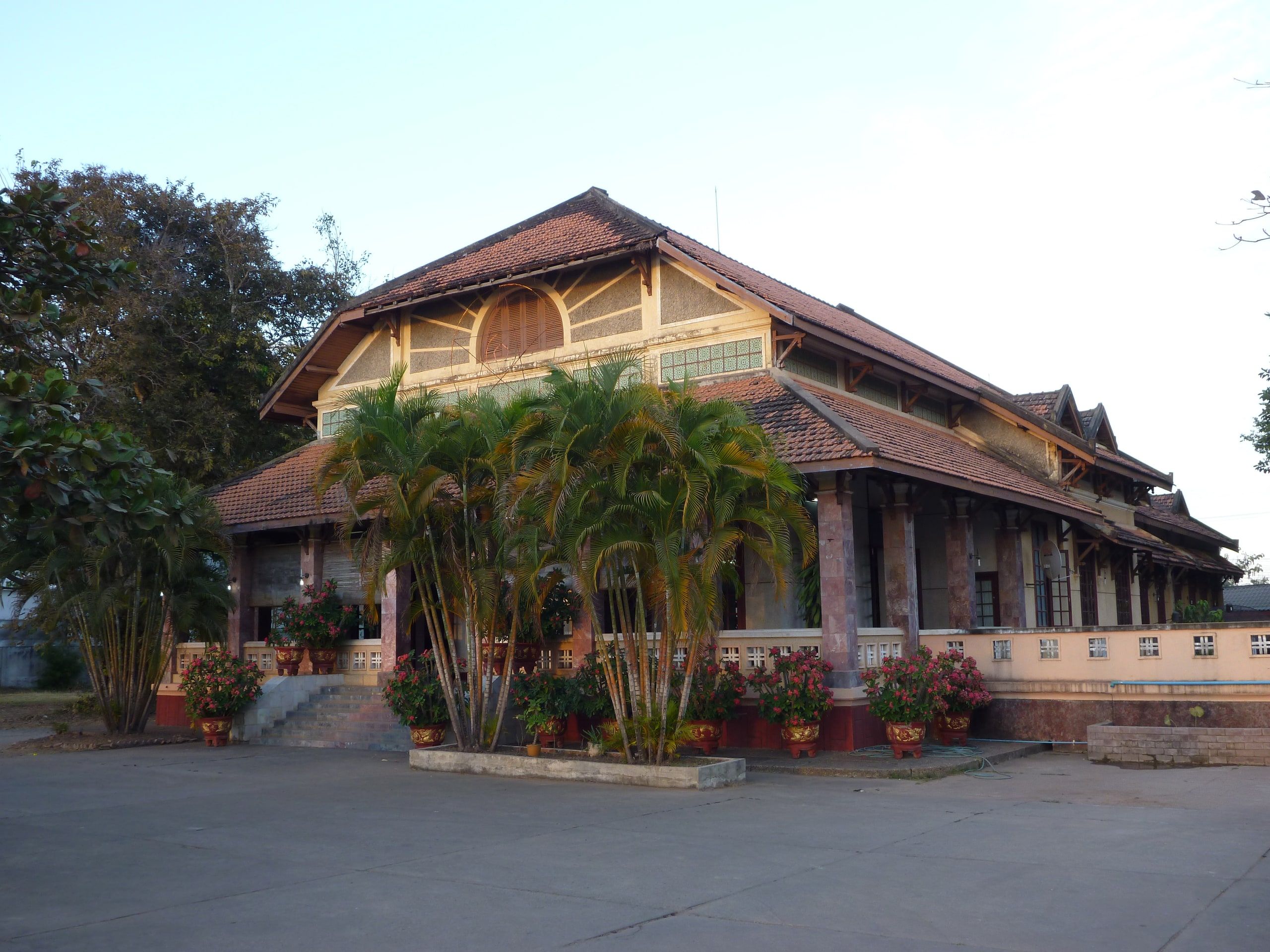 L'hôtel Sooksomboon, une grande bâtisse coloniale à balcons de bois derrière des palmiers