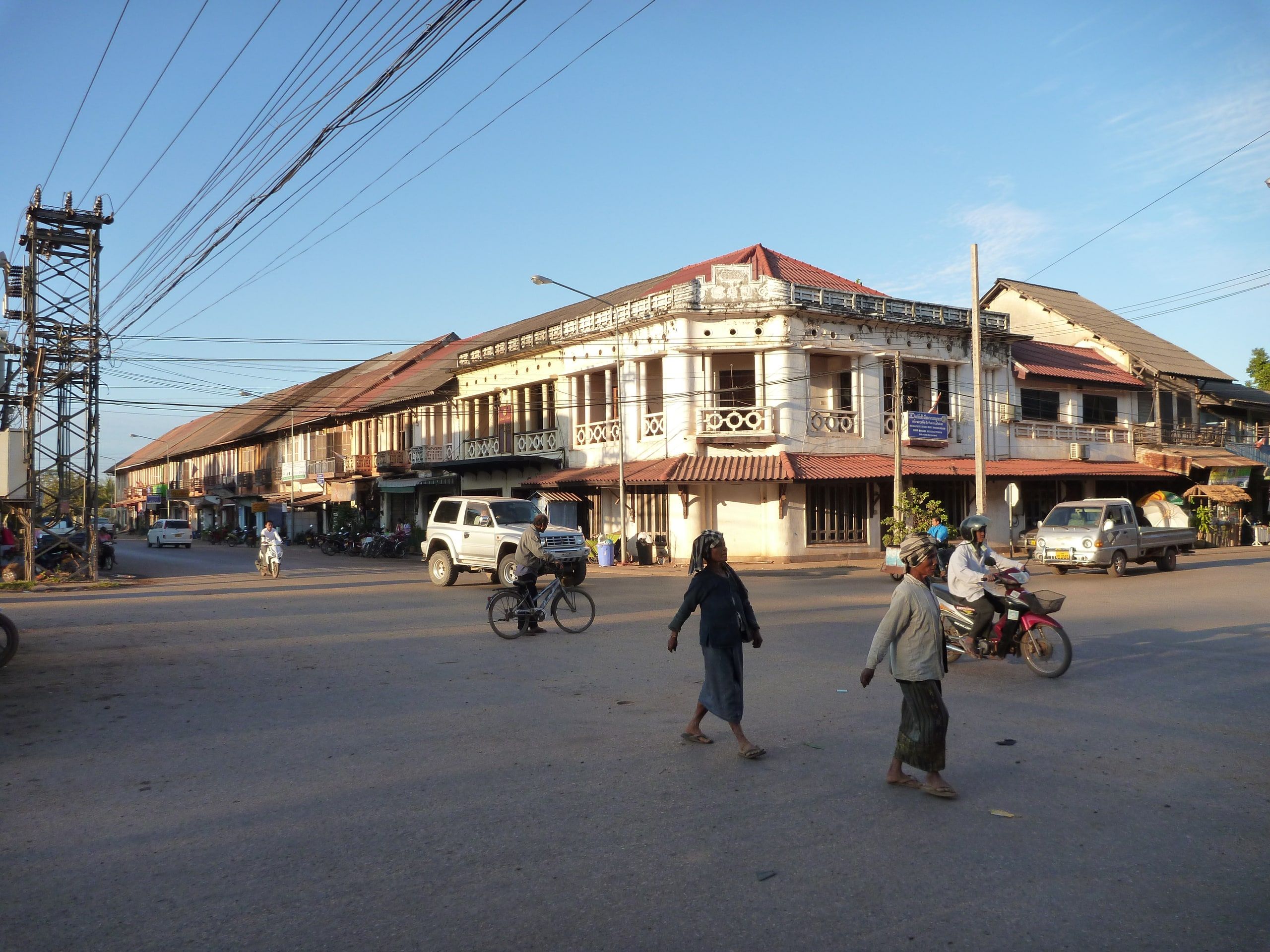 Un carrefour de Thakhek et ses maisons coloniales à arcades, au soleil du soir