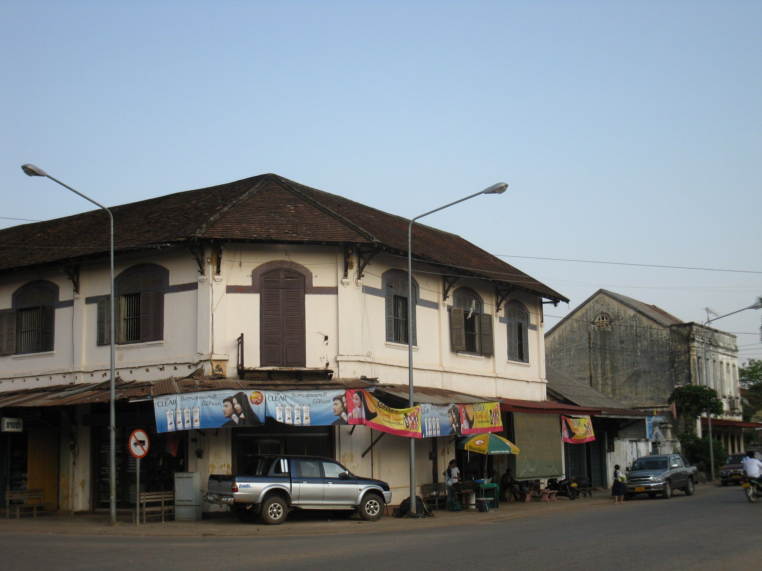 Une ancienne maison coloniale à volets en arc, au coin d'une rue de Thakhek