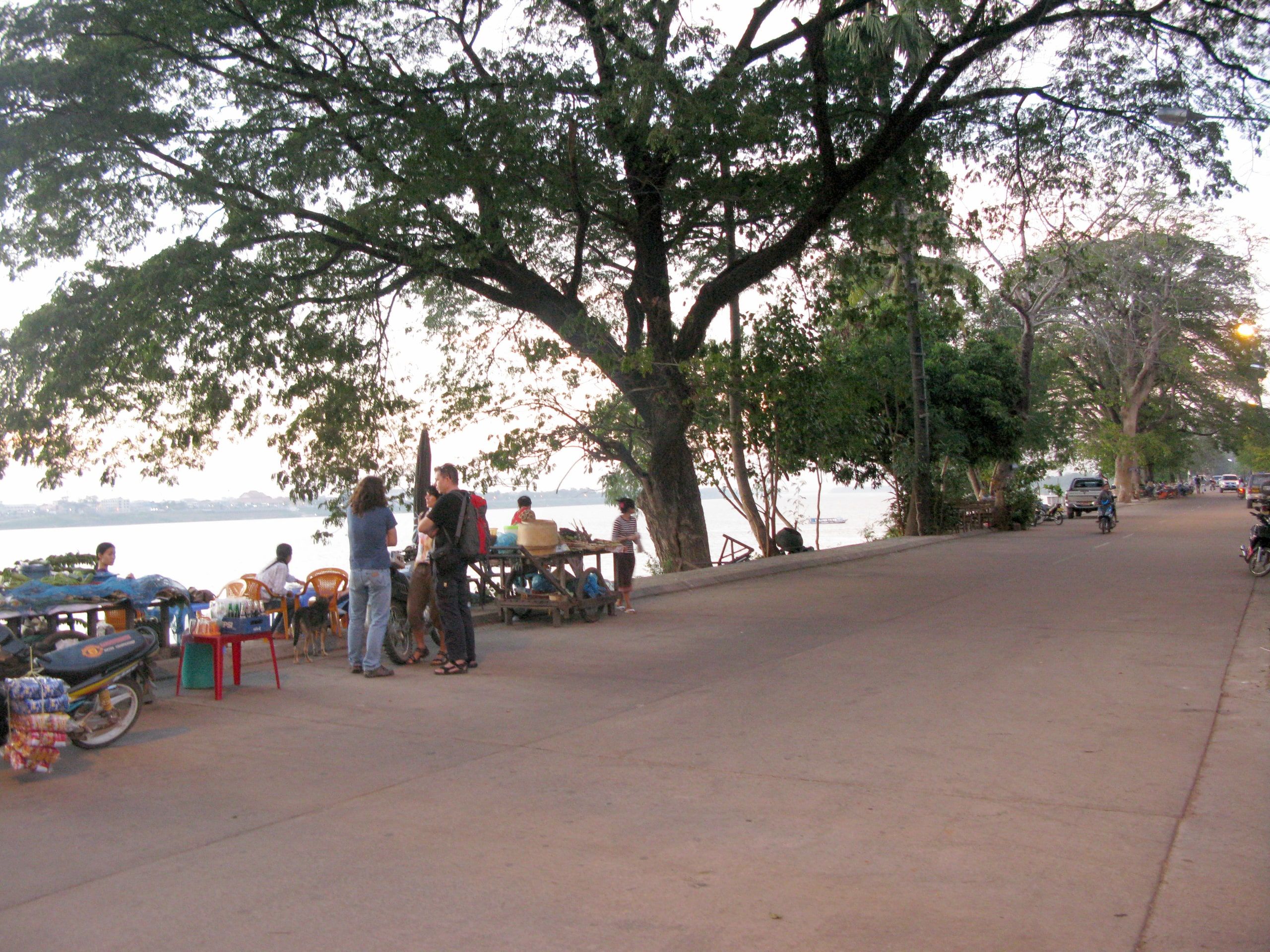 Une rue arborée au bord du Mékong à Thakhek, des étals sous les arbres