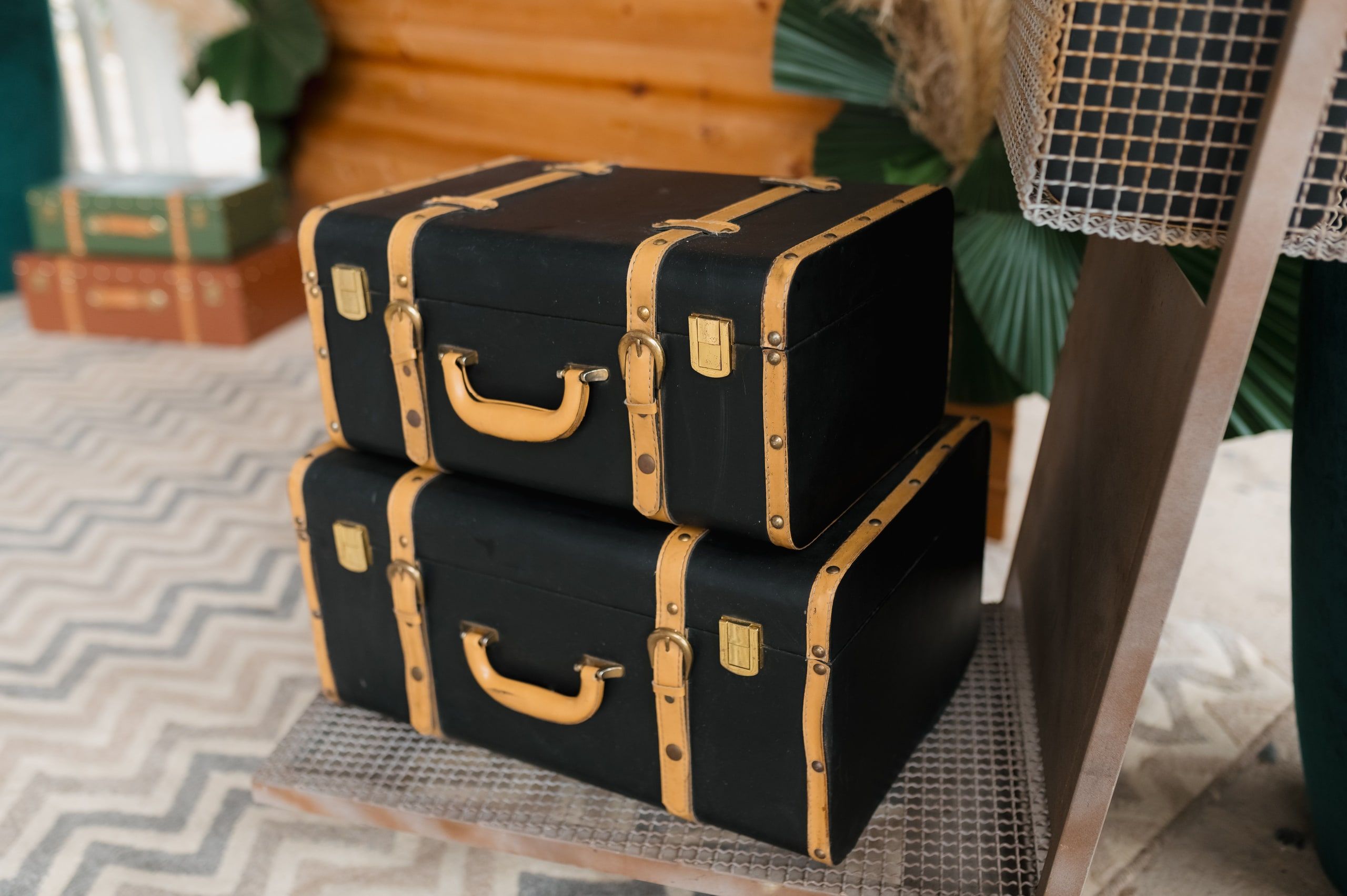 Vintage black suitcases with tan straps, stacked