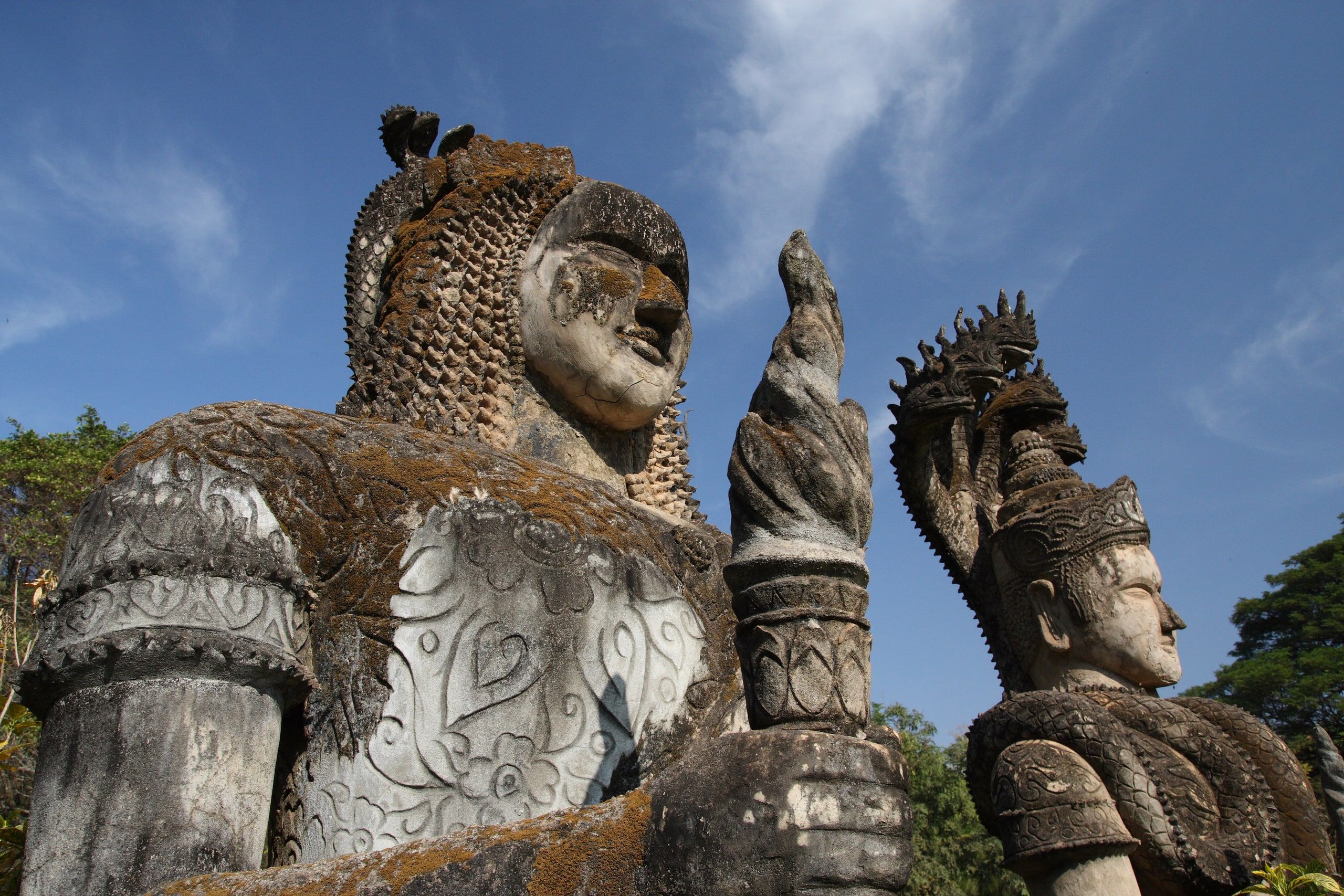 Des statues de béton couvertes de mousse au parc des Bouddhas, Xieng Khuan